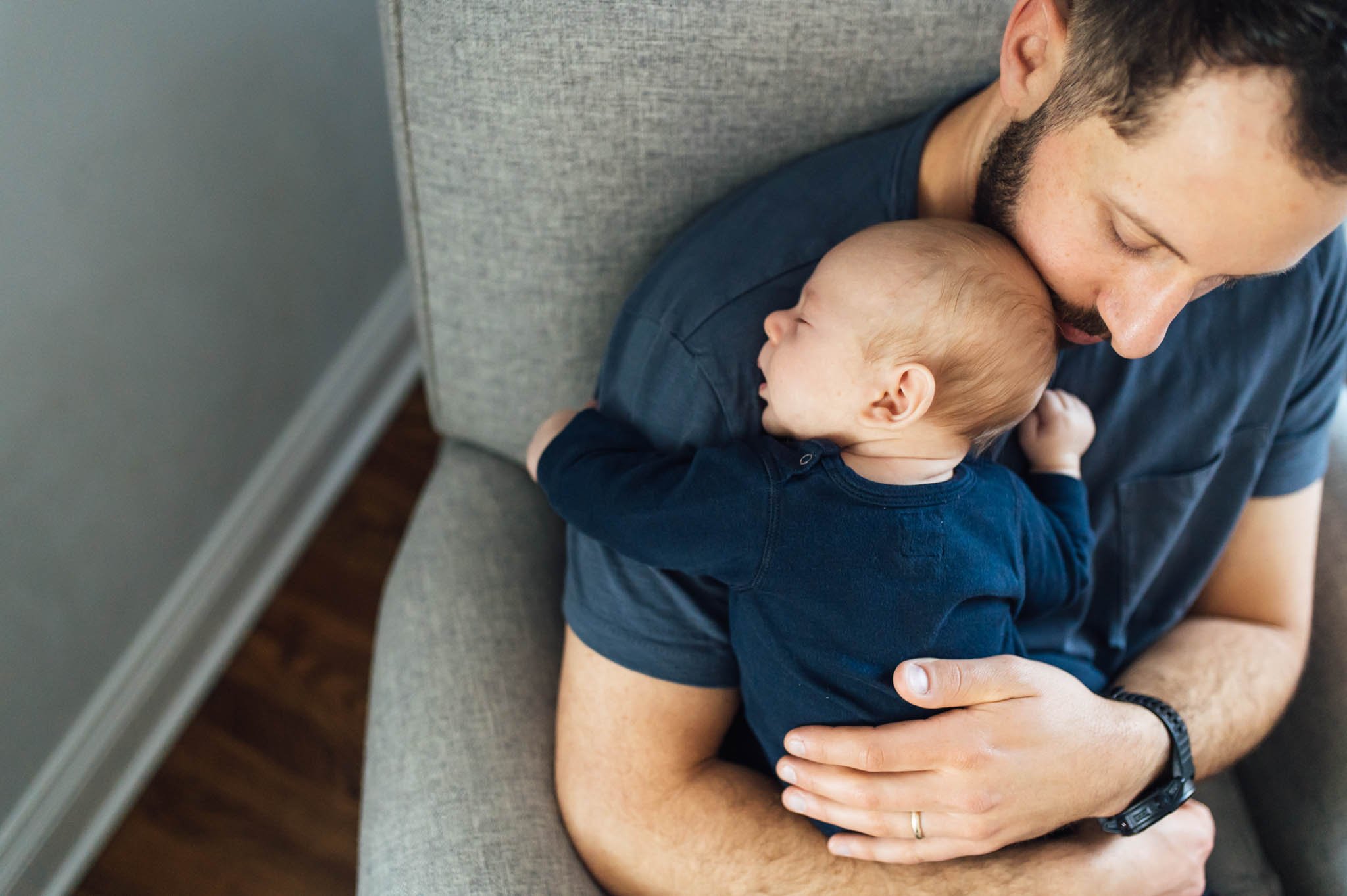 Dad snuggles baby in nursery