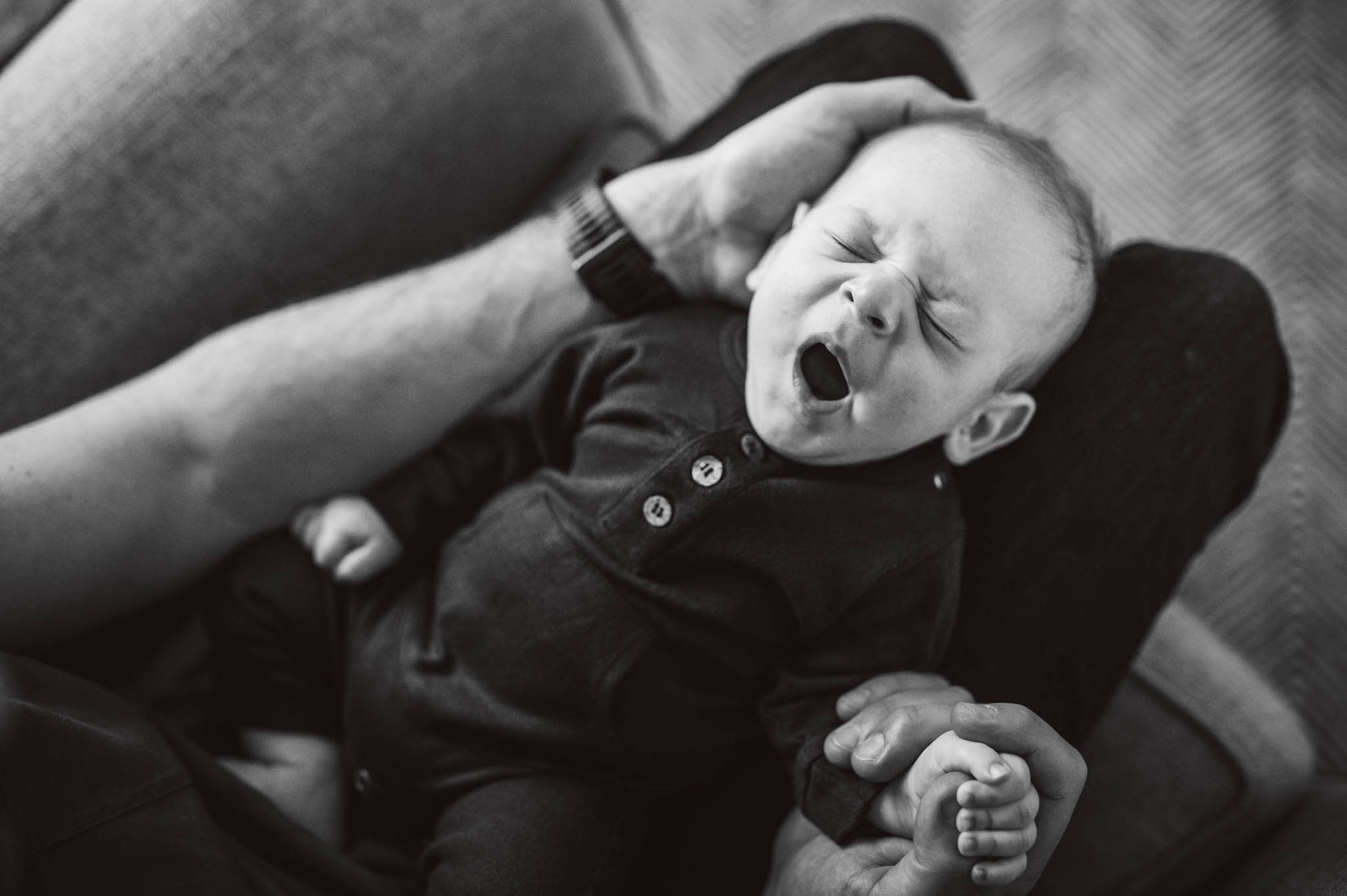 Baby yawns on dad's lap
