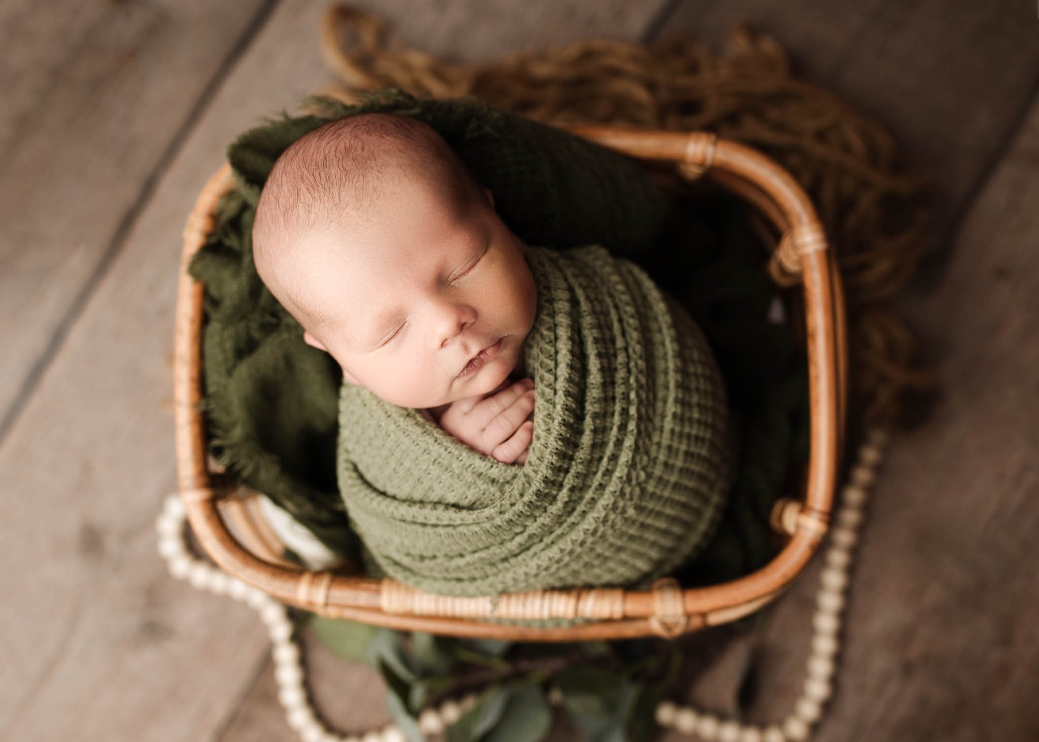 Baby in a basket, green blanket