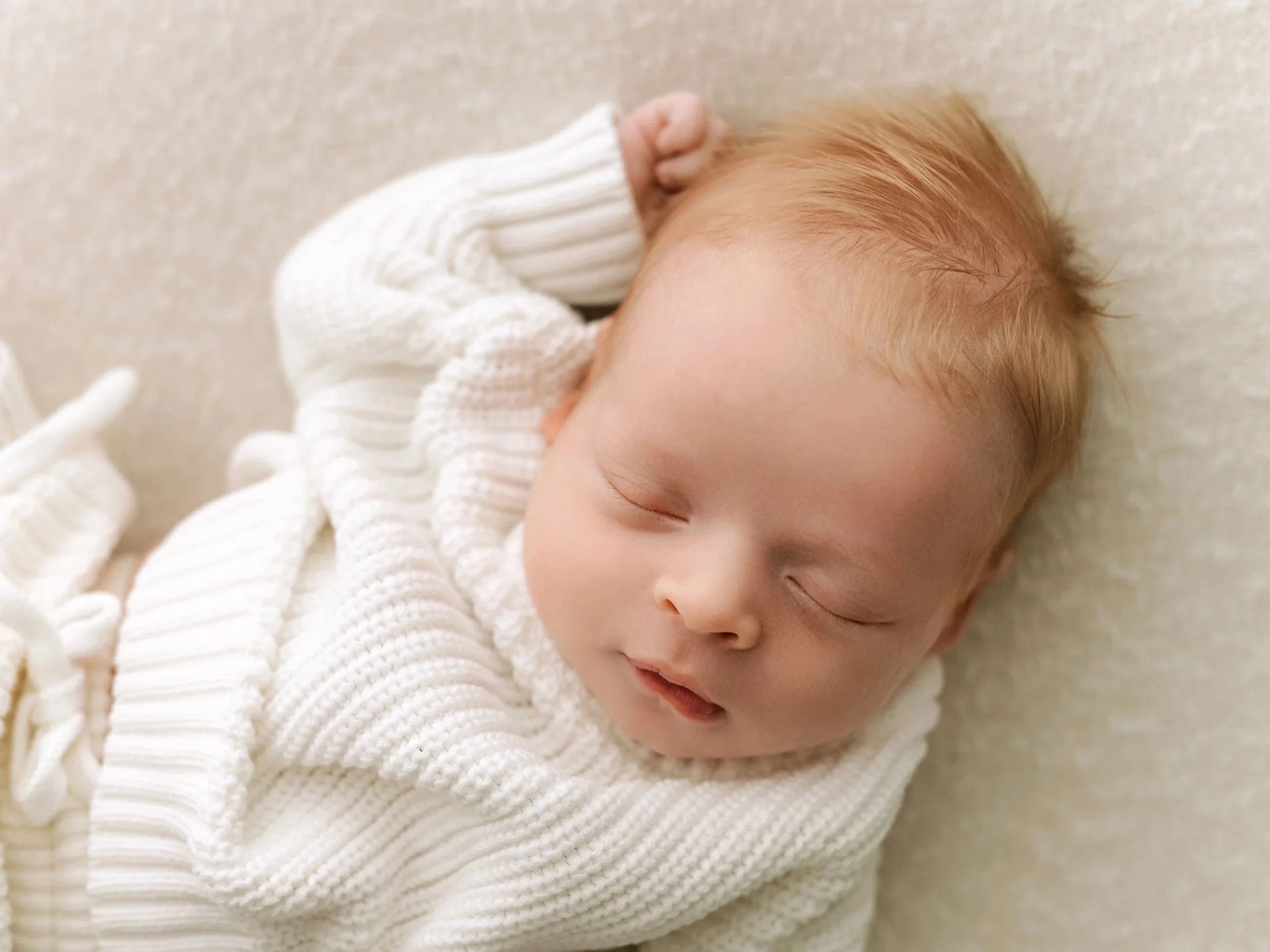 blonde baby boy wearing white sweater sleeps in ridgefield, ct photography studio