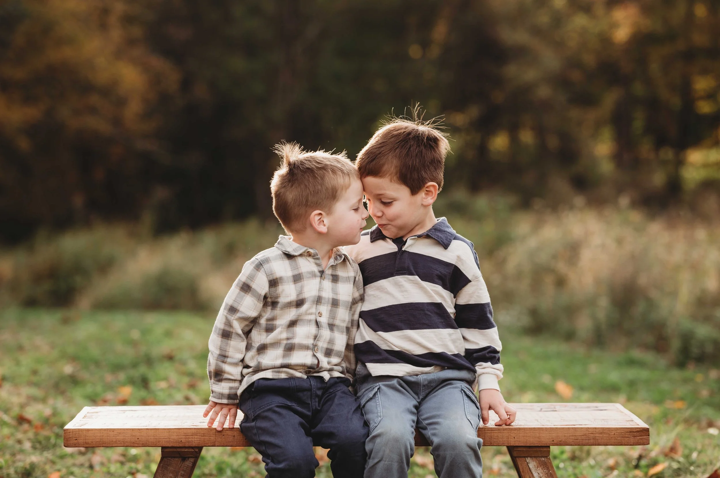 brothers look at each other with funny expressions while sitting on a bench