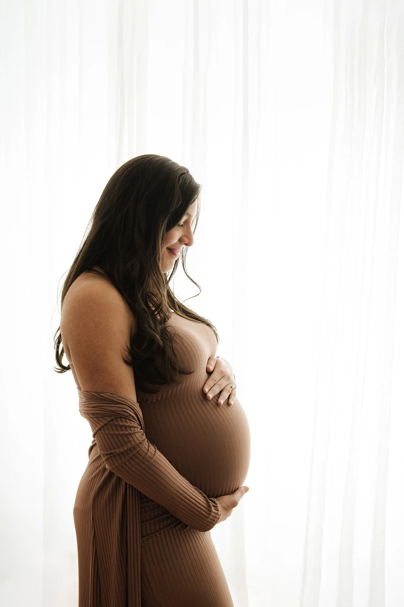 pregnant woman in brown dress stands in profile, maternity photoshoot, ridgefield, ct