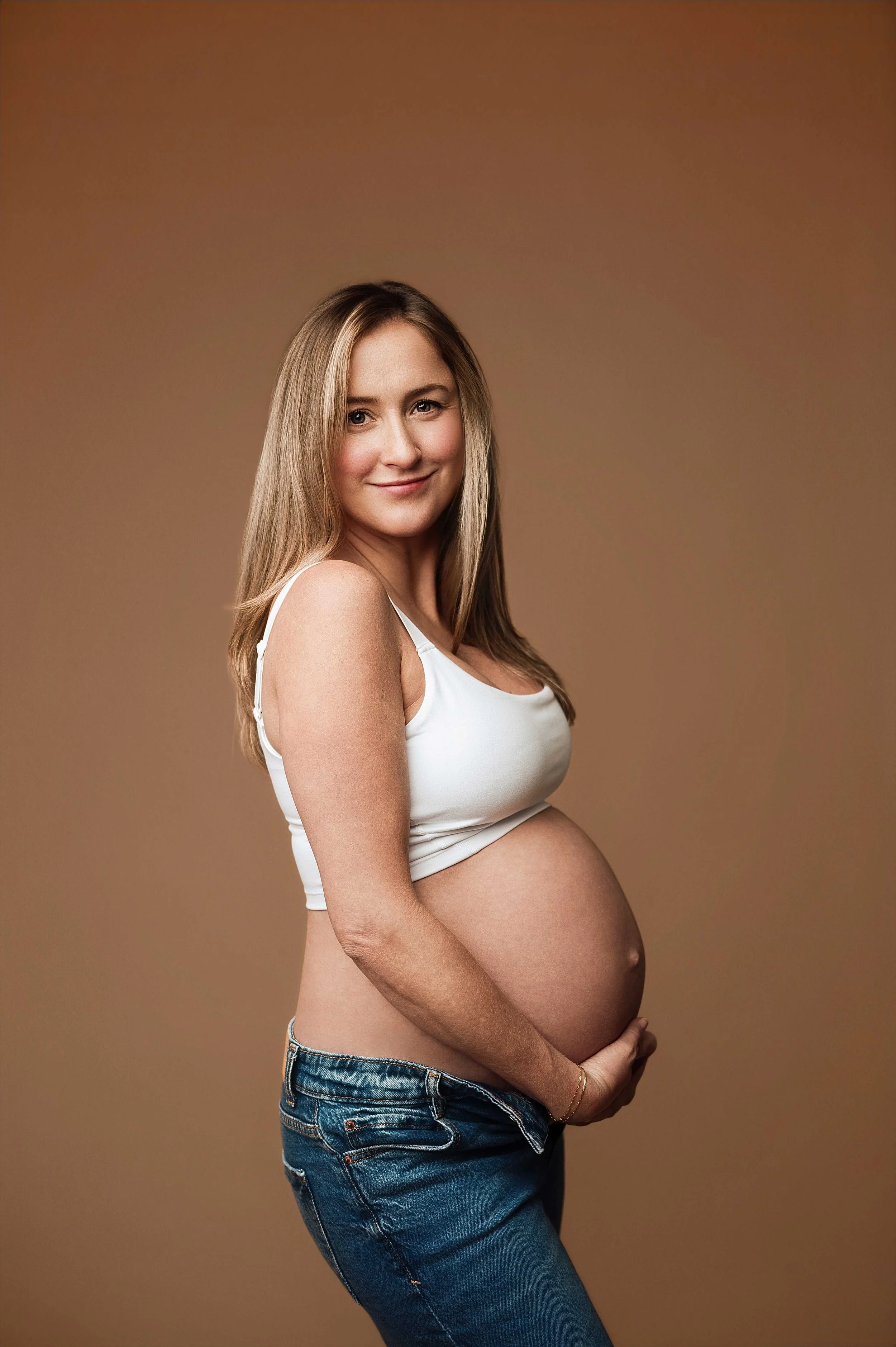Pregnant mom in jeans and crop top, studio maternity session Ridgefield CT