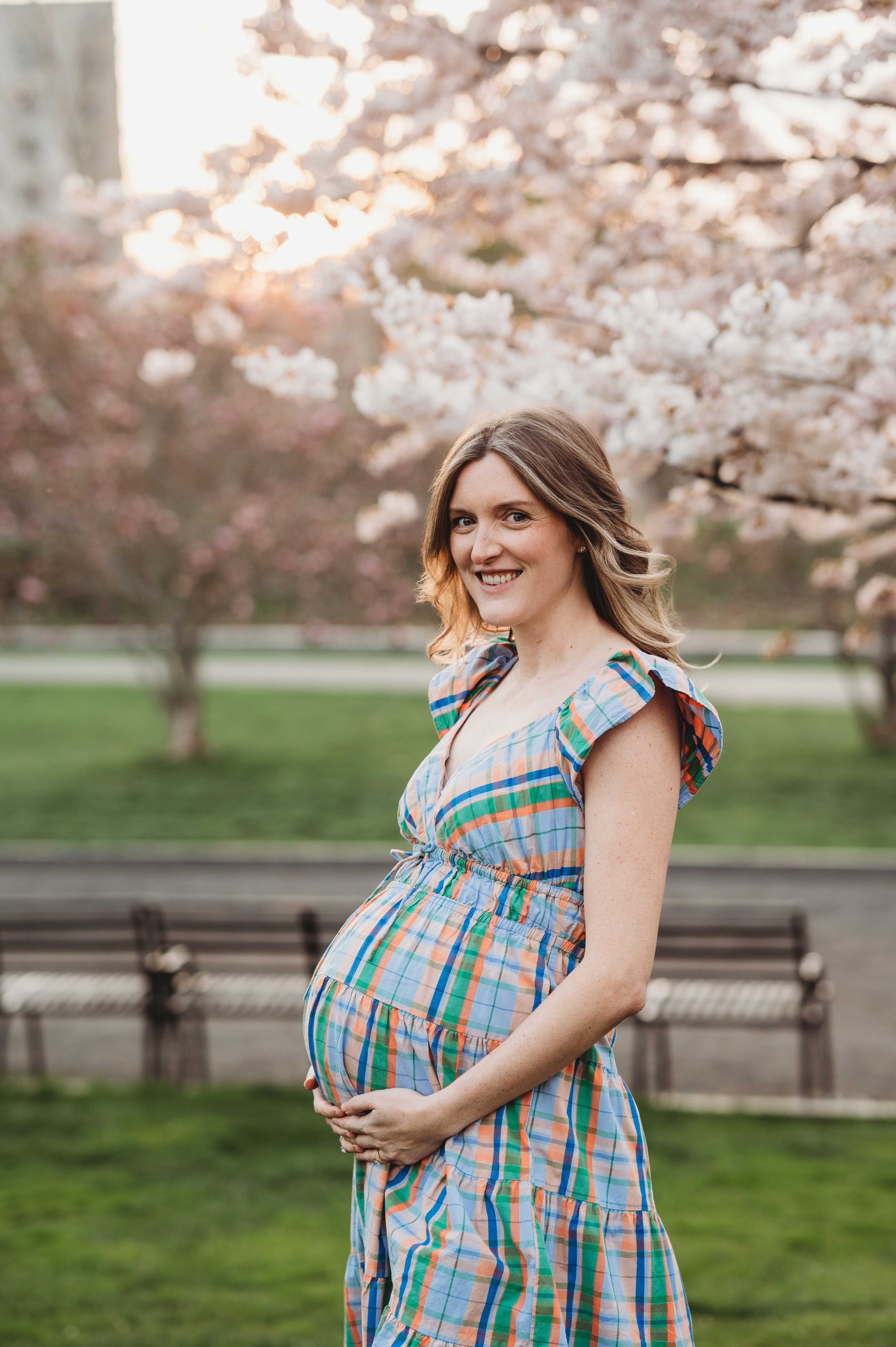 Pregnant woman poses at her maternity photoshoot, spring florals in stamford ct as backdrop