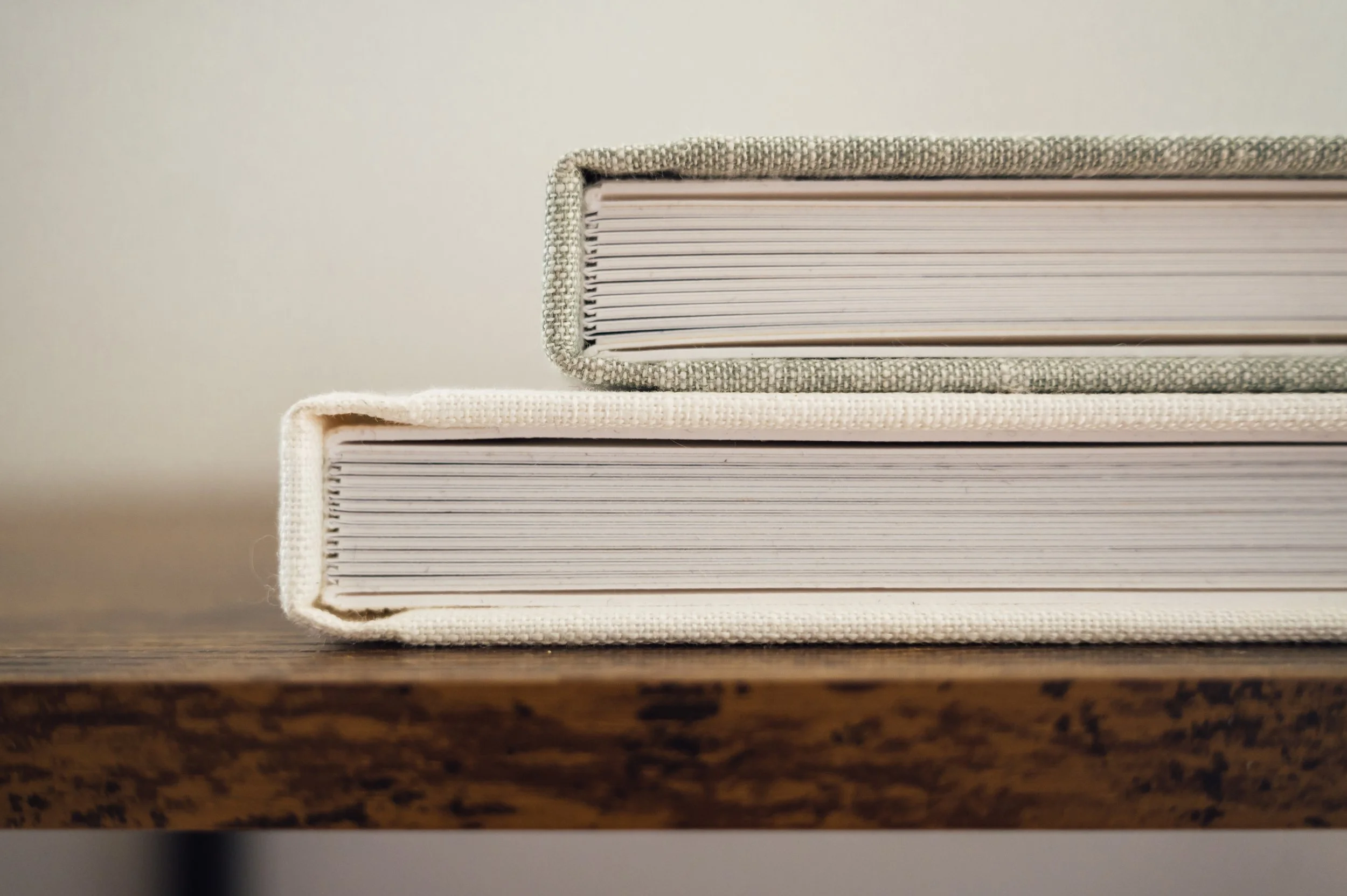two newborn photography albums stacked sit on side table featuring Westchester, ny photoshoots