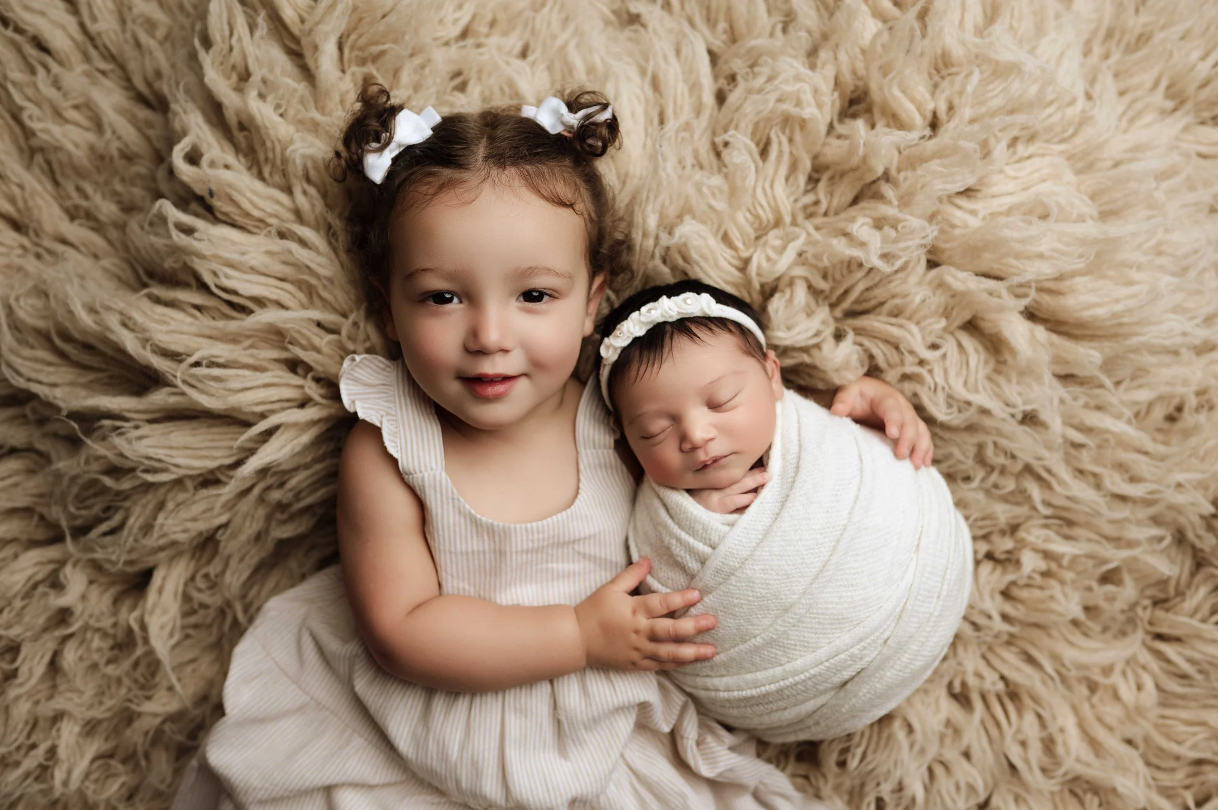 baby girl in white wrap sleeps with older sibling snuggles in ridgefield ct studio