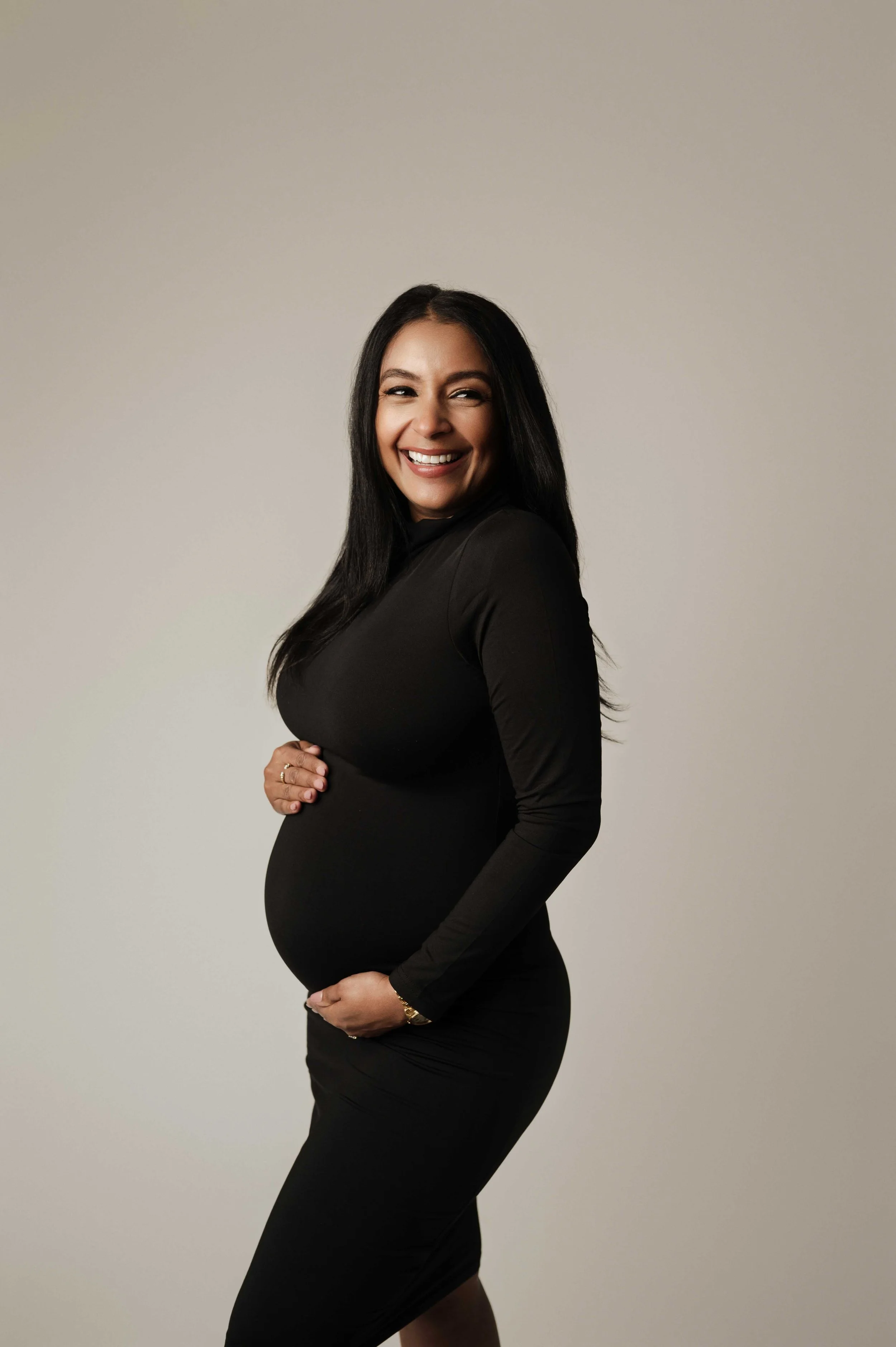 Expecting mom in fitted black dress, studio maternity photography Ridgefield CT