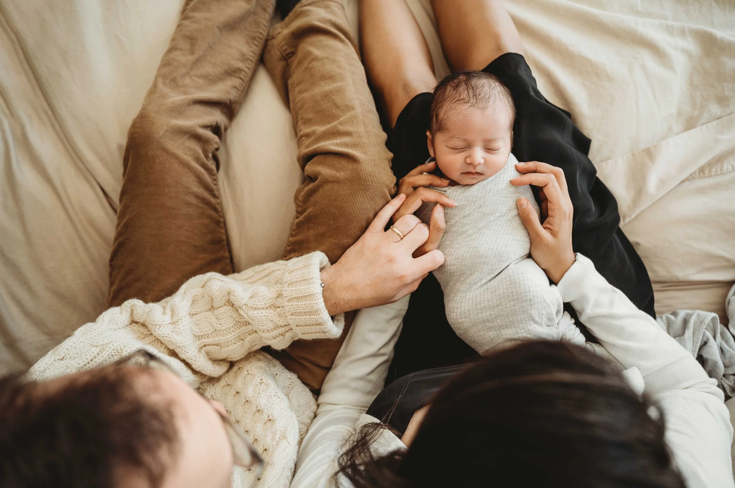 parents look down at baby son, lifestyle newborn photography session in stamford, ct