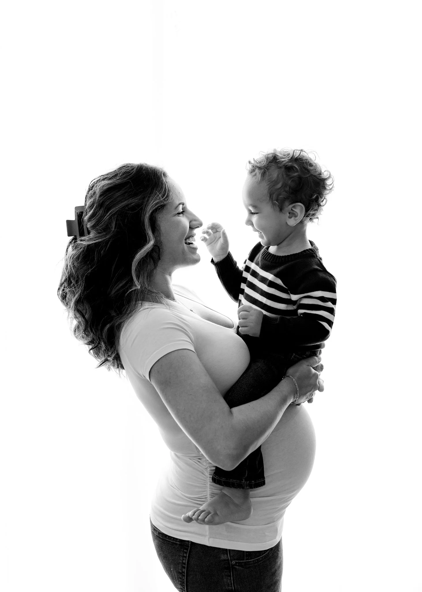 pregnant woman holds toddler son above bump in ridgefield, ct studio