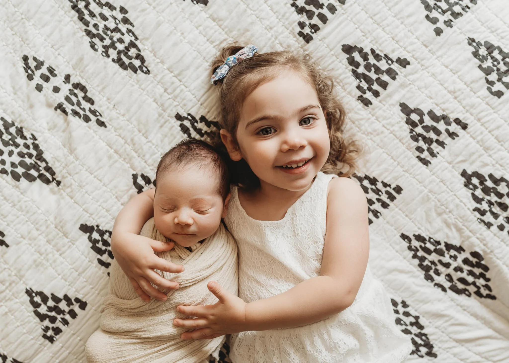 toddler girl hugs newborn baby, in-home lifestyle photoshoot ridgefield ct