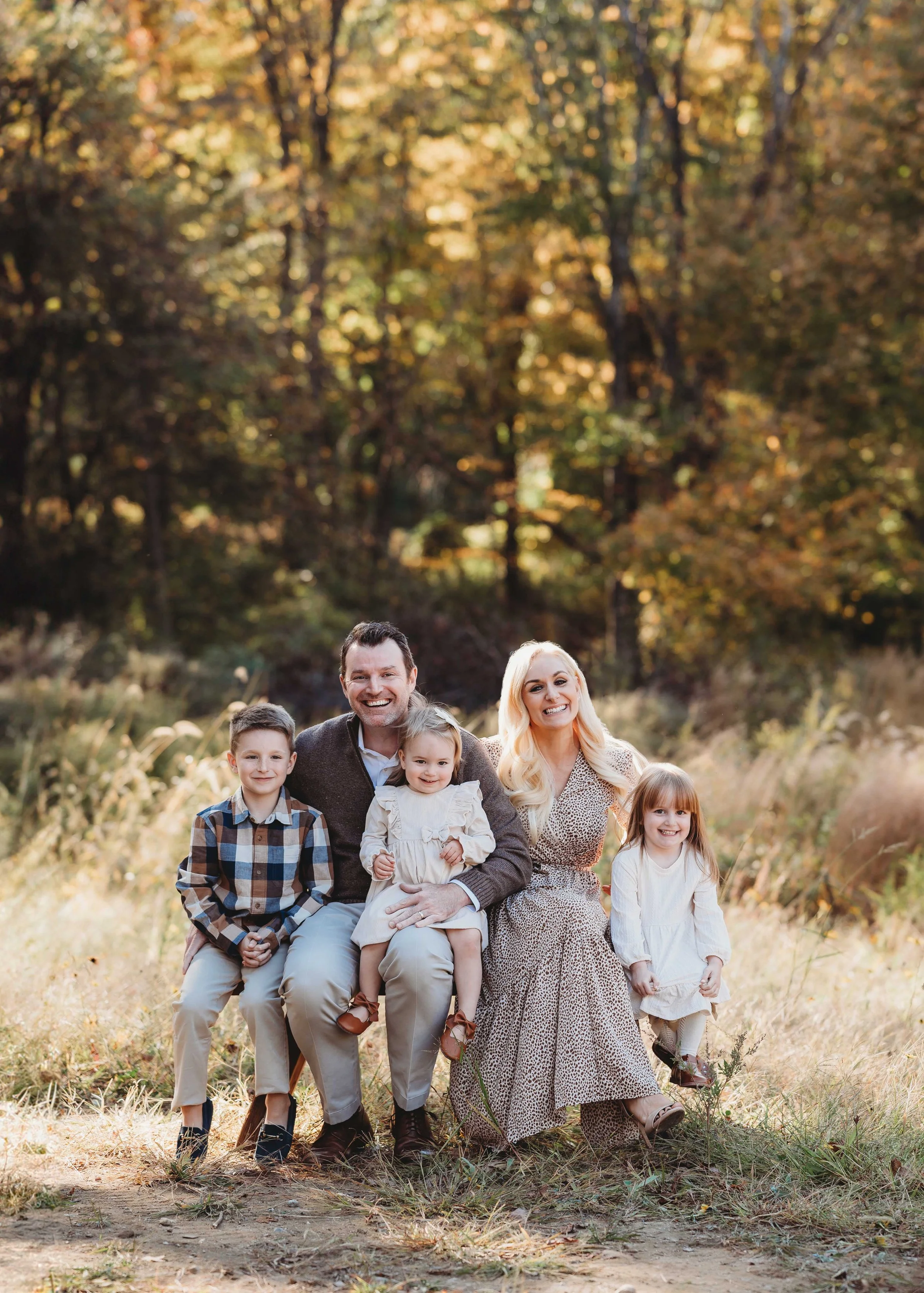 family of five smiles at camera with fall foliage backdrop, Westchester, ny photoshoot