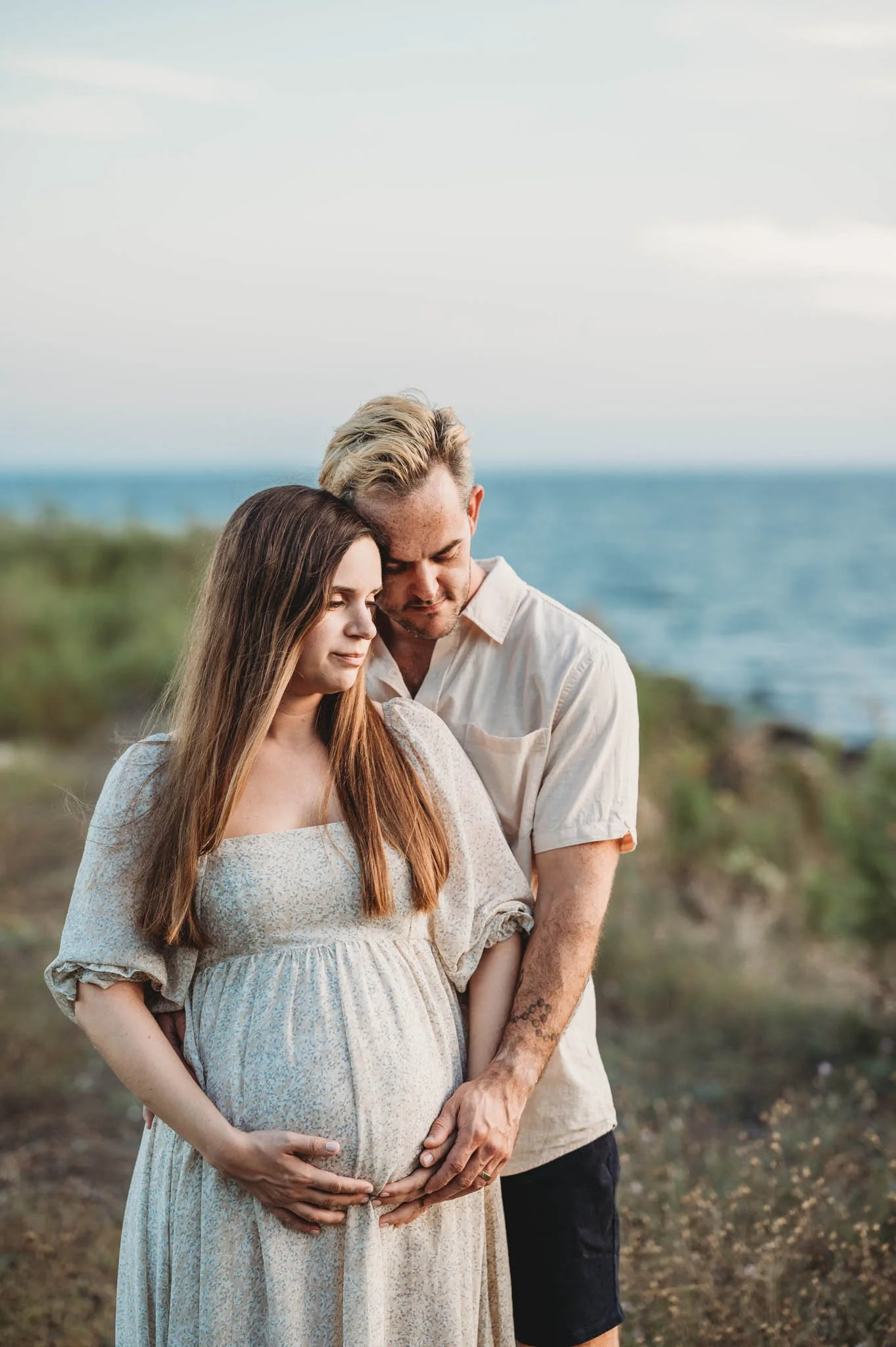 expecting couple cradles bump on beach, maternity photoshoot in Fairfield County