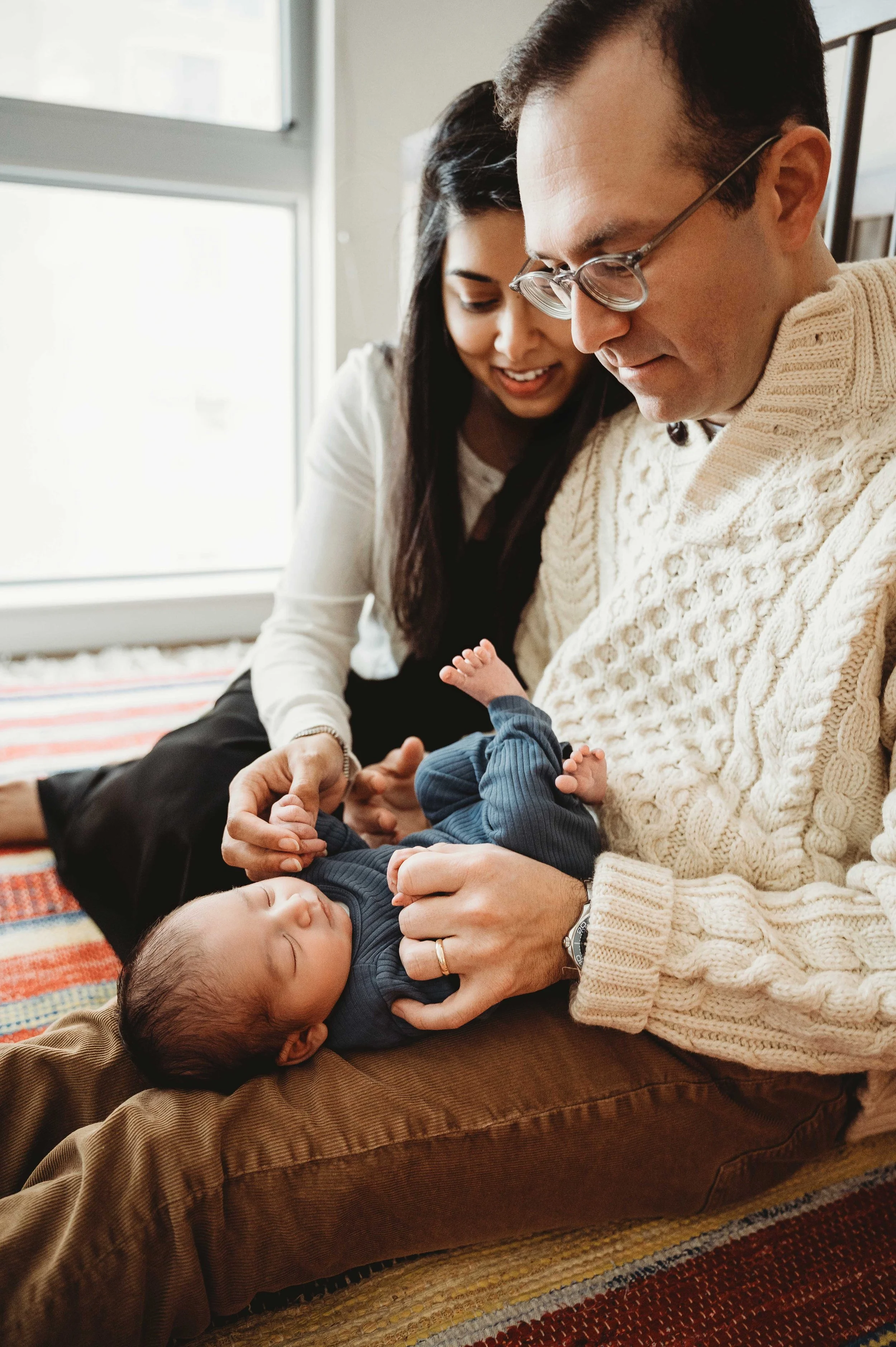a couple in stamford, ct looks down at their baby boy during the lifestyle newborn photoshoot