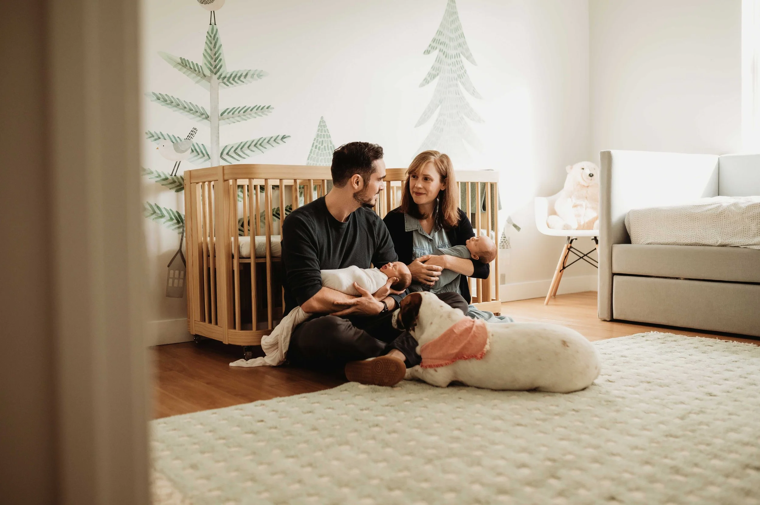 parents hold newborn twins during a lifestyle in-home photoshoot in Fairfield County