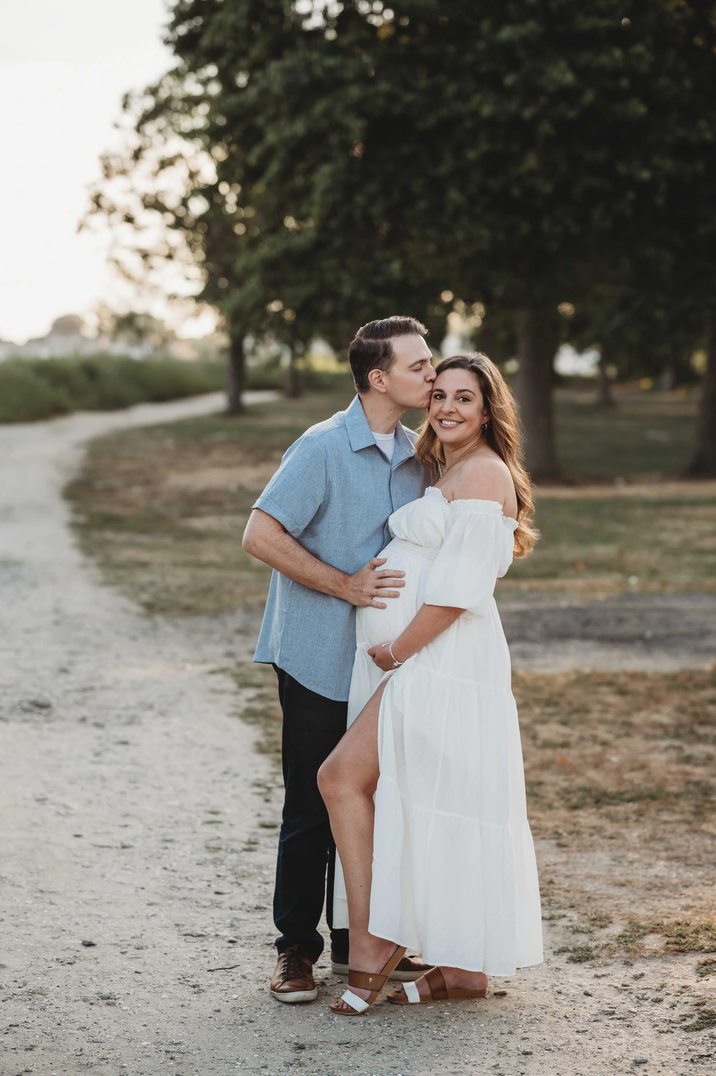 pregnant woman poses with husband, golden hour photoshoot