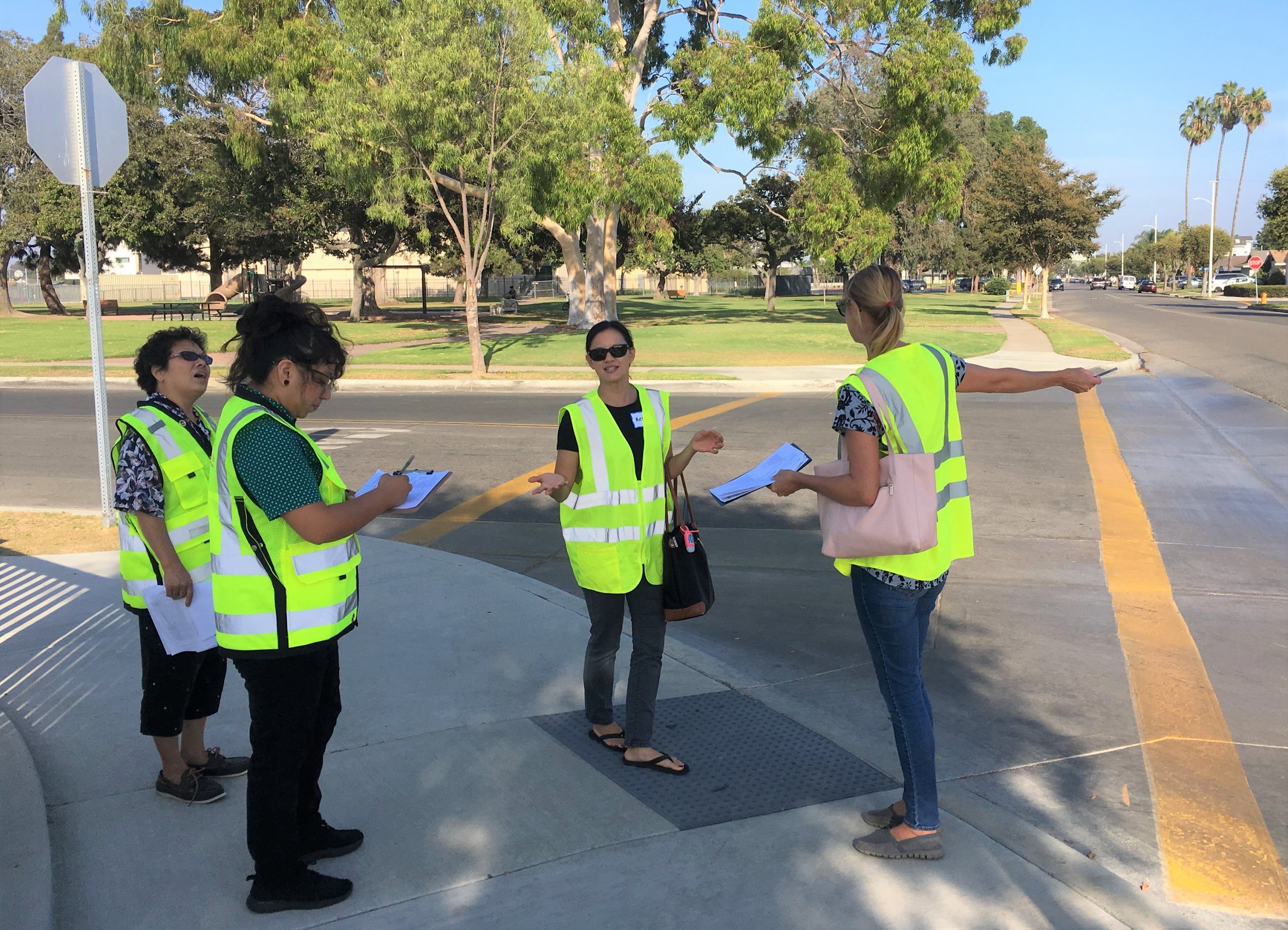 Personal de Cal Walks dirigen a padres en una evaluación de la seguridad peatonal sobre rutas usadas por estudiantes para llegar y salir de la escuela en Huntington Beach.