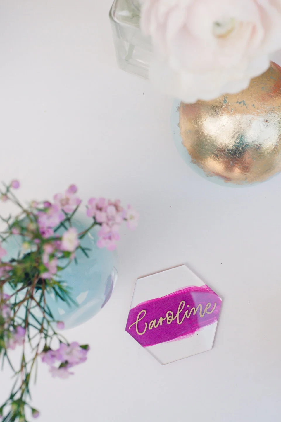 Hexagon acrylic place cards with painted backs, gold ink, and modern calligraphy.