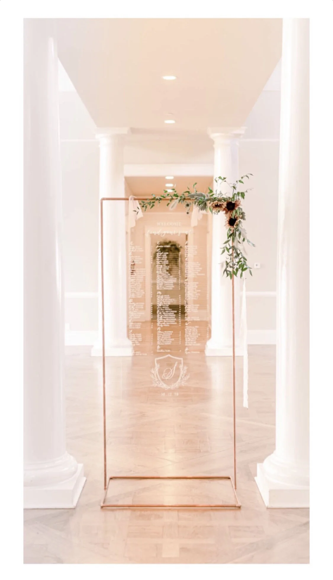 Acrylic seating chart with copper stand and fall florals.