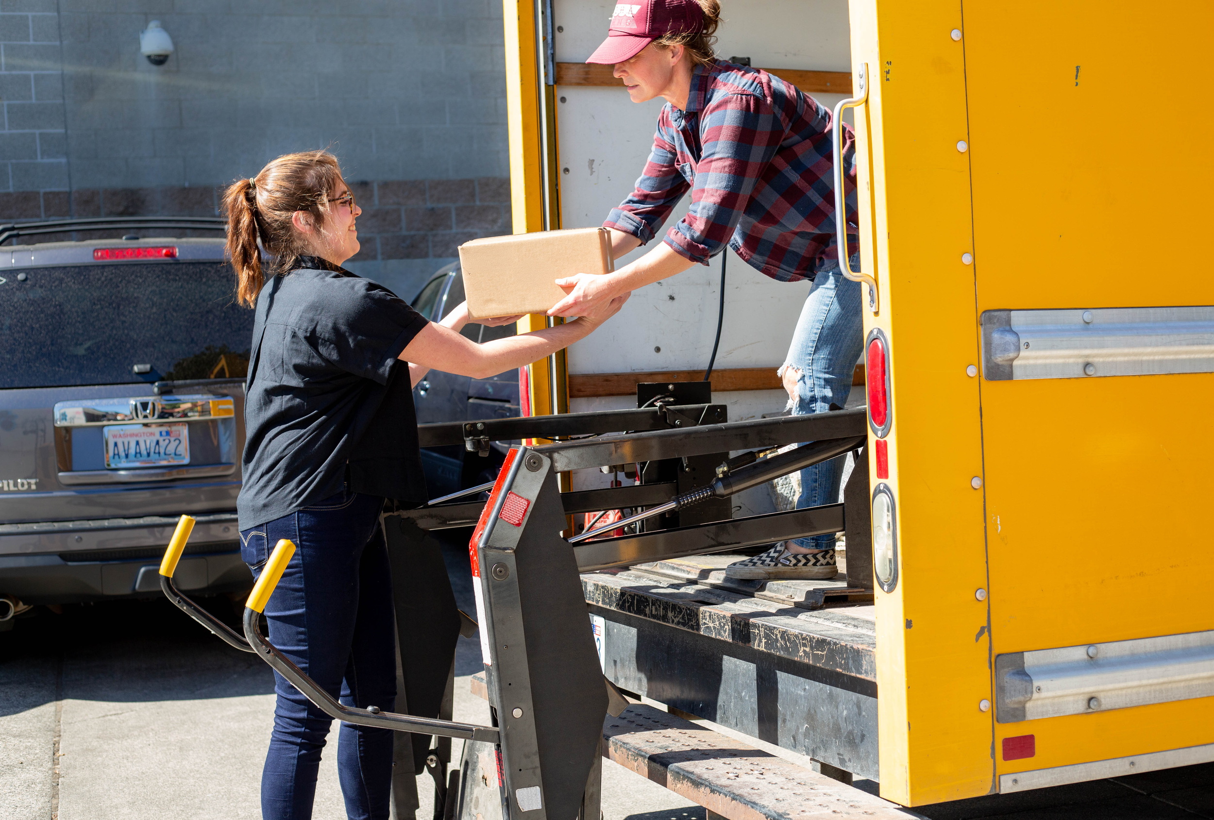 Farm delivery handing off boxes from driver to customer