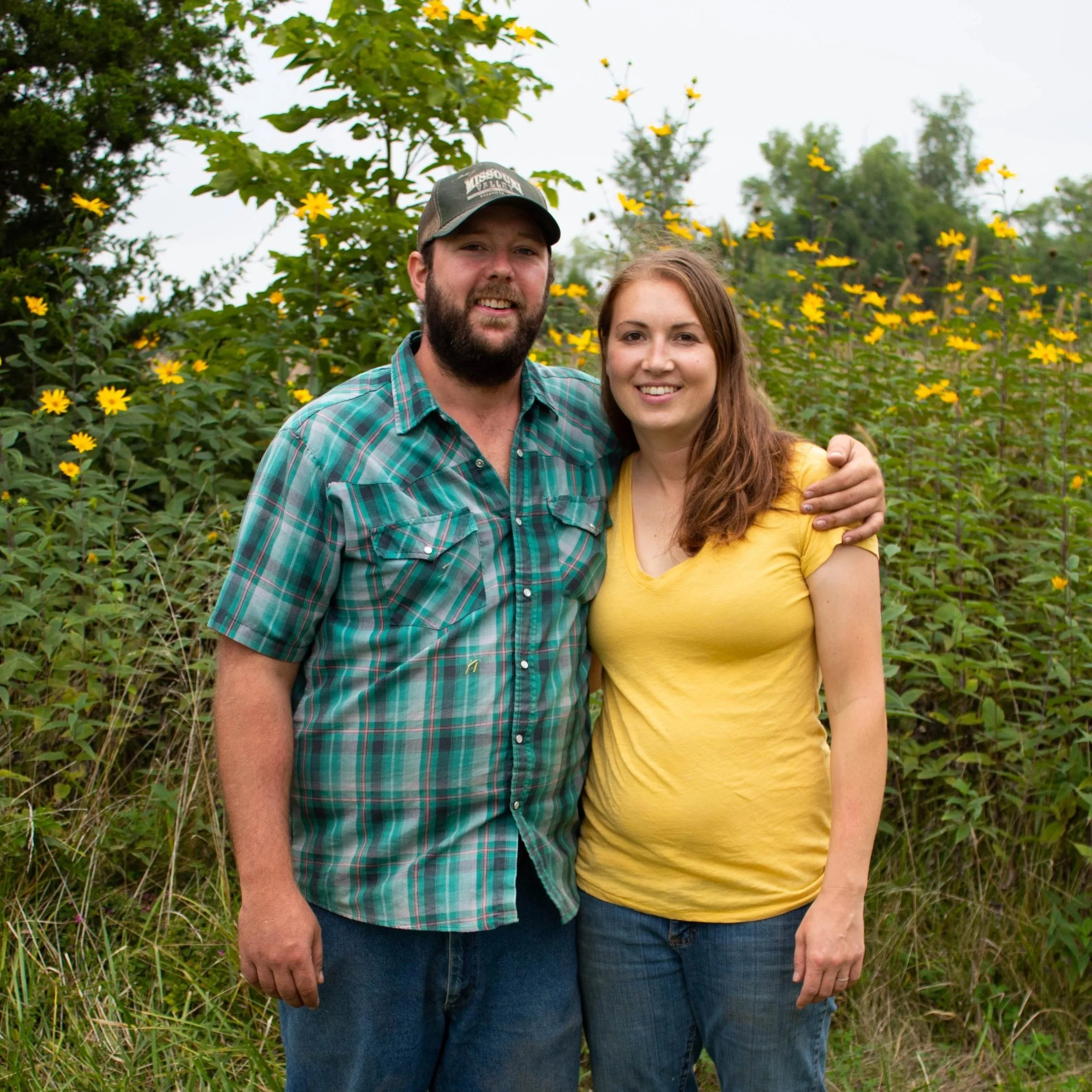 Two local farmers in front of flowers