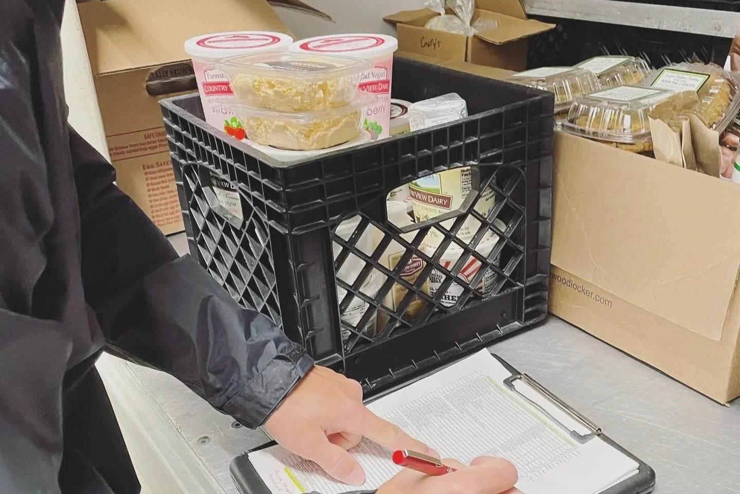 A black crate full of farm fresh dairy products