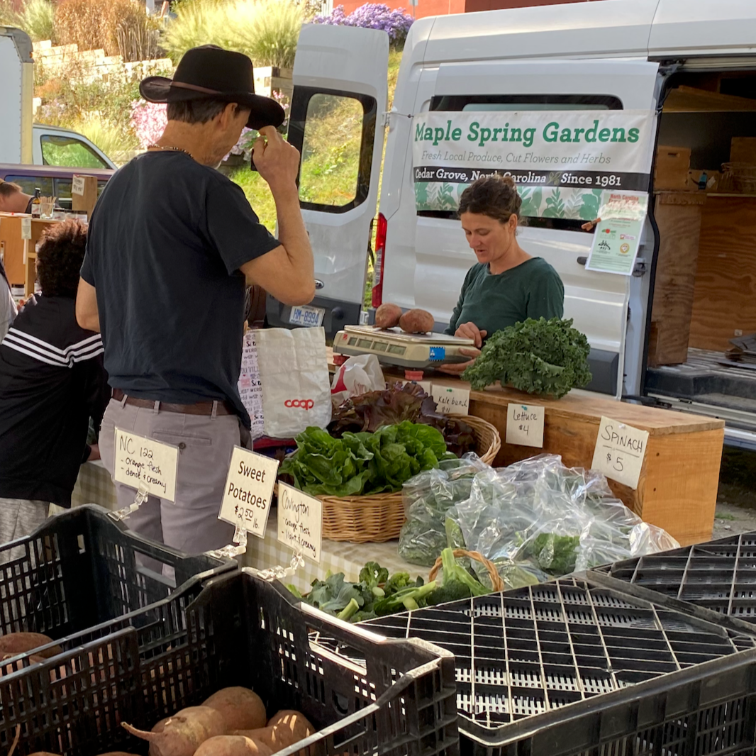 A local farmer weighing produce at a farmers market
