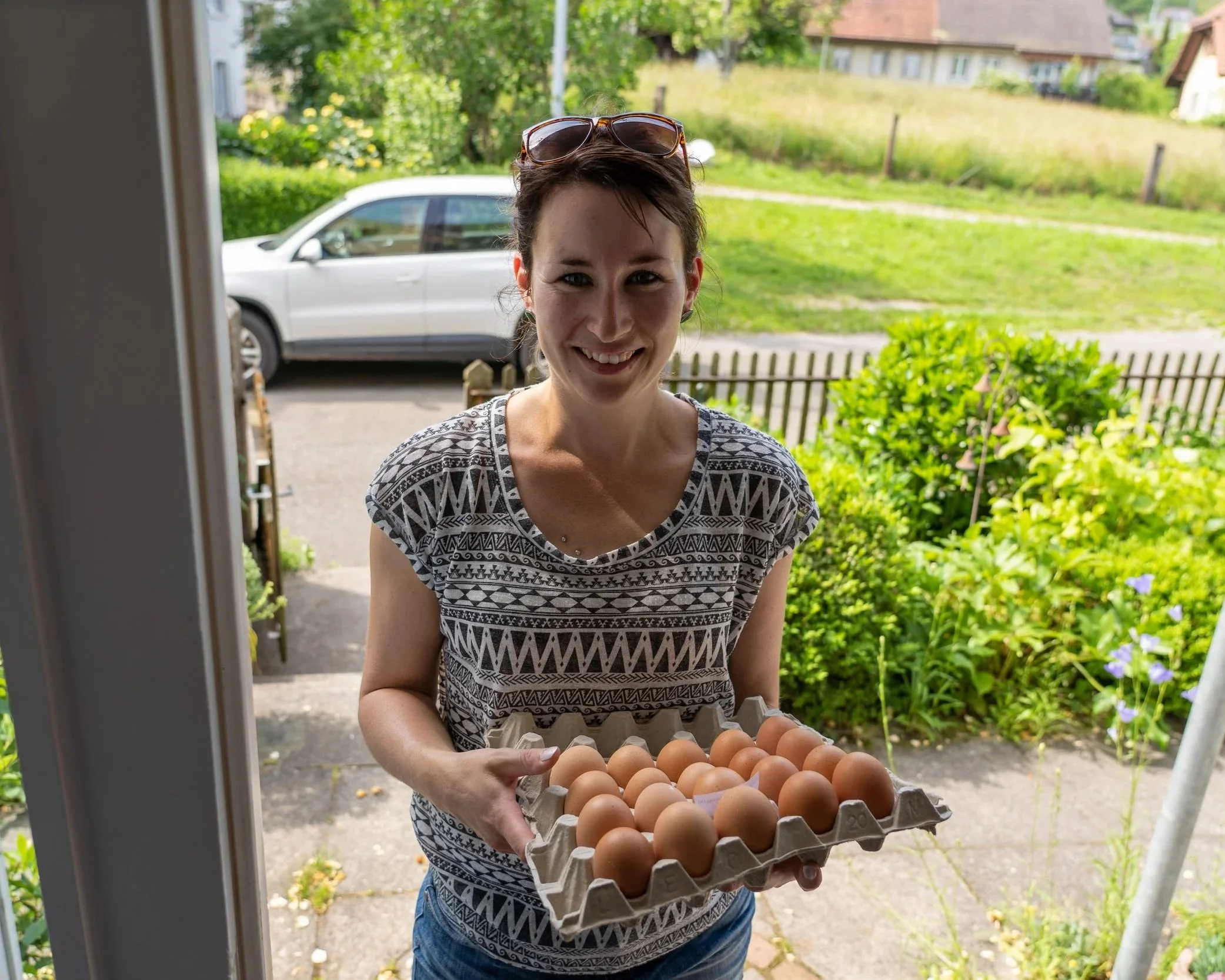 A delighted buyer receiving farm fresh eggs at her door