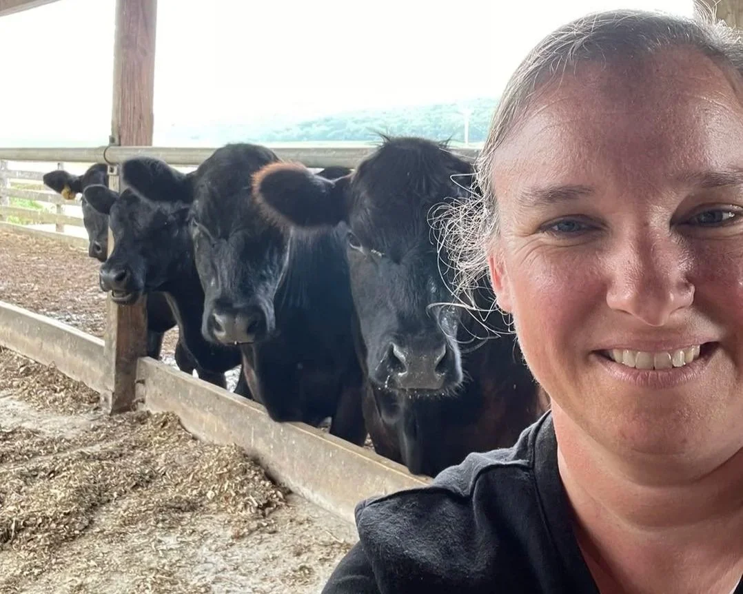 A local farmer taking a selfie with her cows