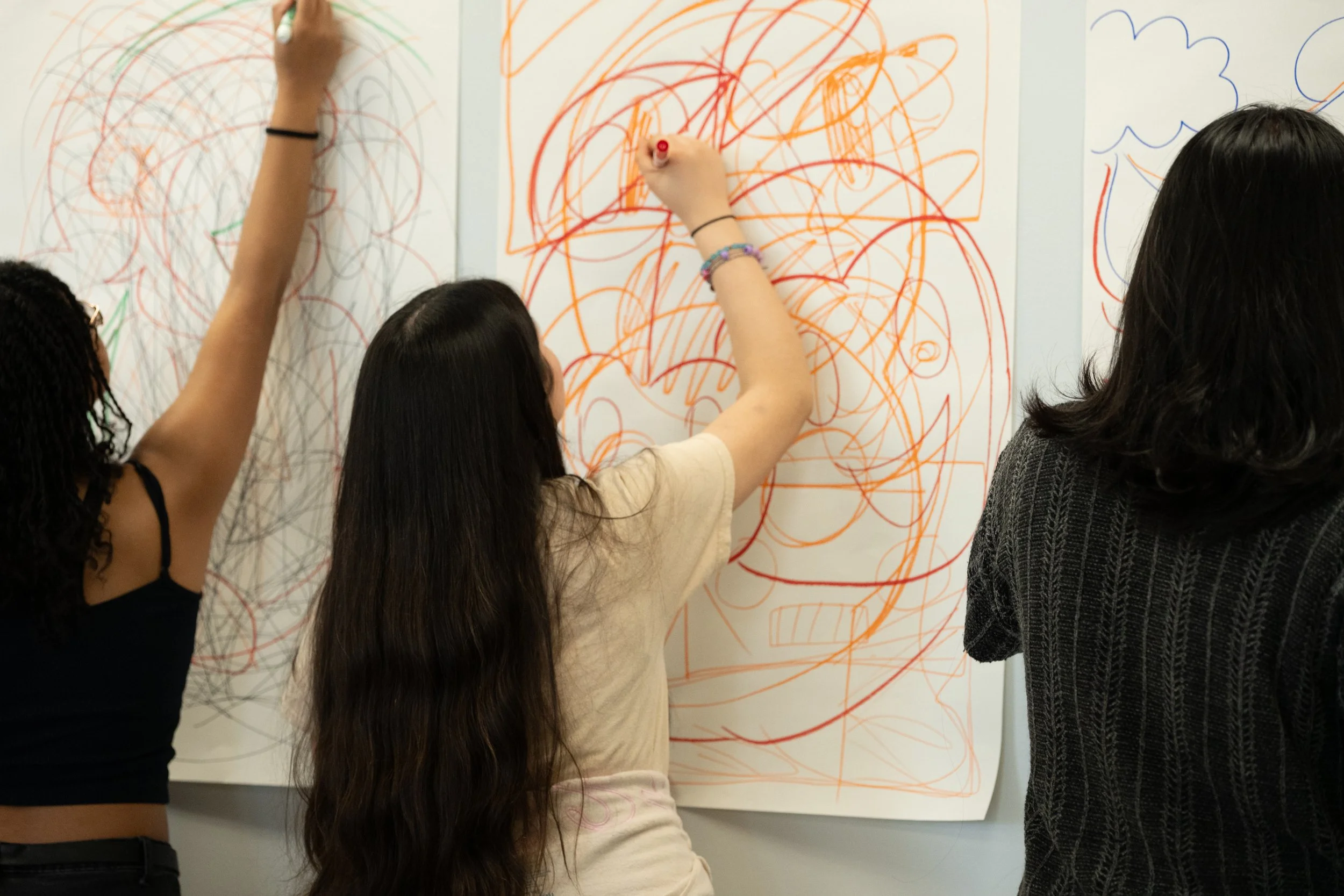 Students of Everett High School practice thinking big and taking up space by creating large fluid lines, shapes, designs, etc