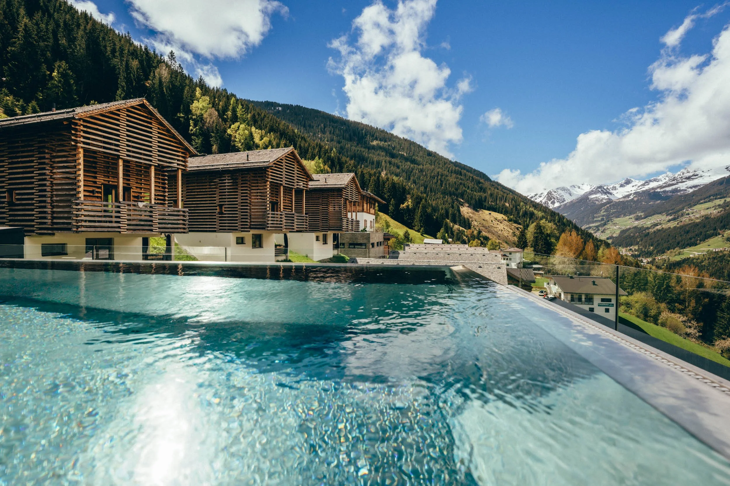 Sommerliche Hotelfotografie des Poolbereichs mit atemberaubendem Ausblick – betont den exklusiven Charakter des Hotels und hebt seinen luxuriösen Charme sowie die beeindruckende Umgebung hervor.