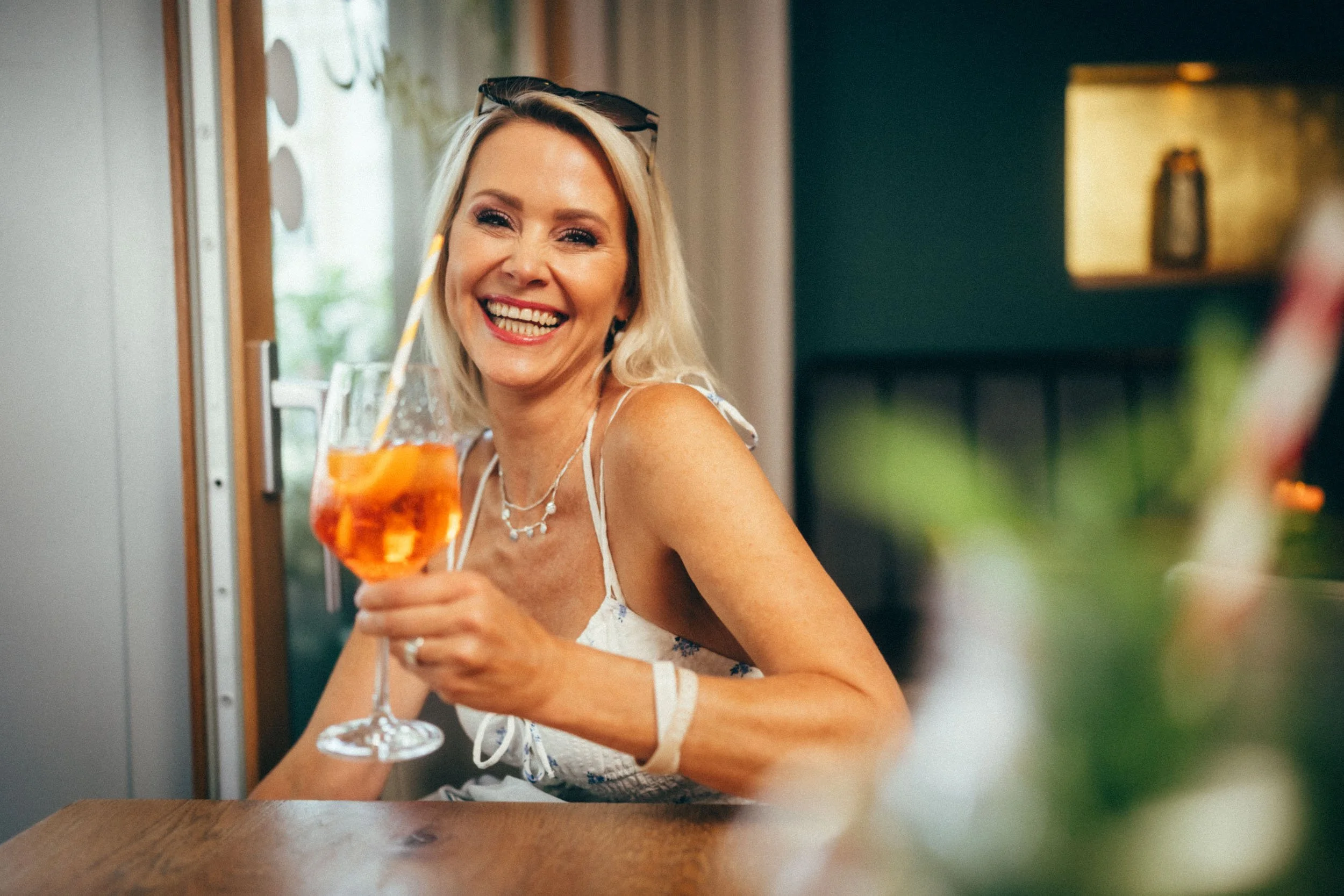 Elegante Restaurantfotografie einer Frau, die in einem gehobenen Lokal ihren Drink genießt – perfekt, um das außergewöhnliche Ambiente und die hochwertige Atmosphäre des Restaurants zu präsentieren.