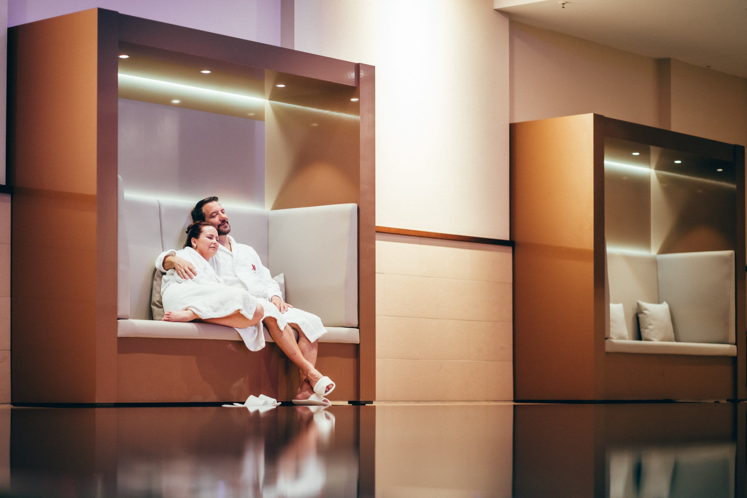 Exklusive Hotelfotografie eines Paares, das am eleganten Hotelpool entspannen – ideal, um das luxuriöse Ambiente und die entspannende Atmosphäre des Hotels zu präsentieren.