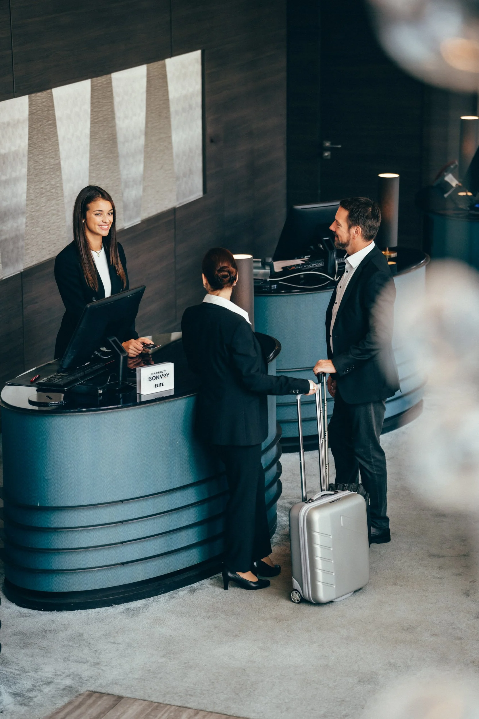 Hochwertige Hotelfotografie eines Hotelgasts an der Rezeption – unterstreicht den persönlichen und professionellen Service des Hauses.