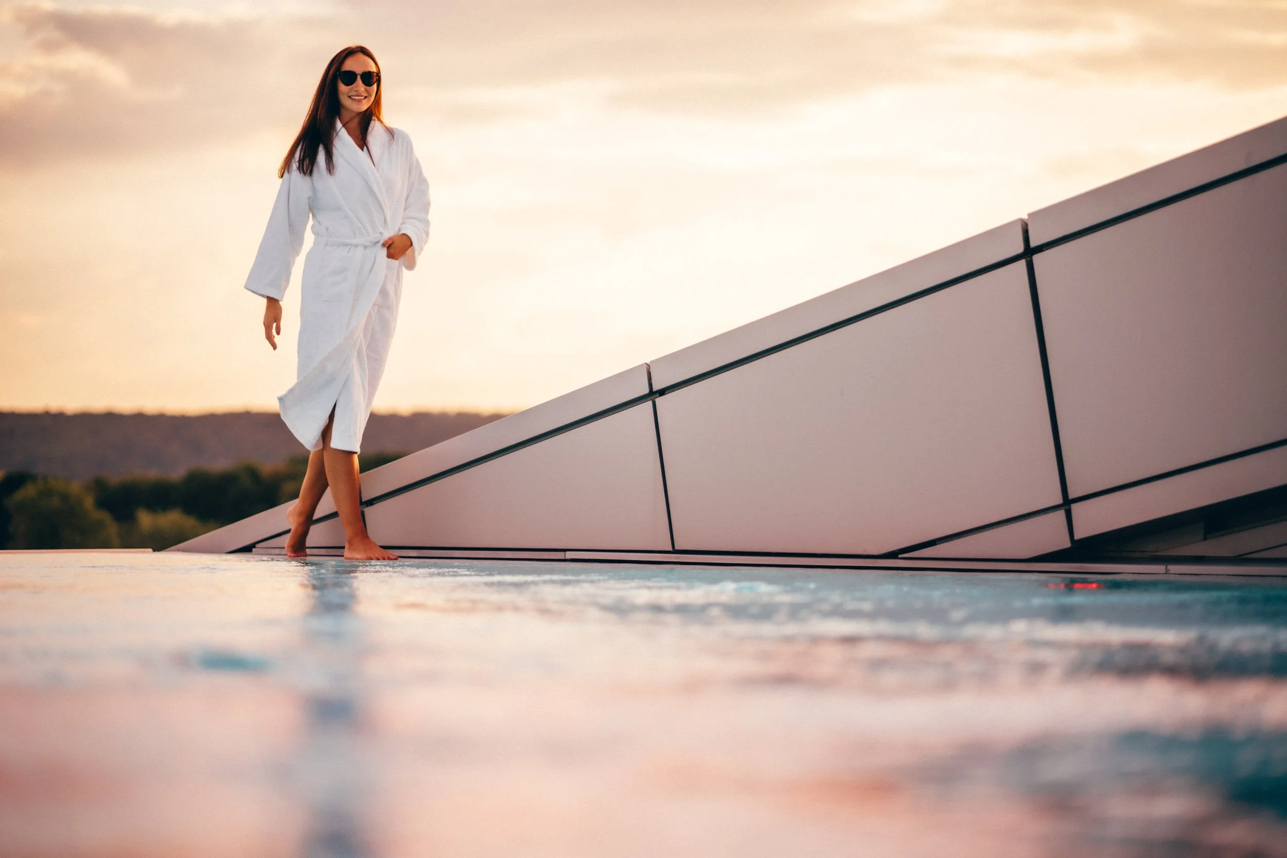 Stimmungsvolles Foto eines Rooftop Pools im Sonnenuntergang – ideal, um das luxuriöse Wellness-Erlebnis visuell zu unterstreichen.