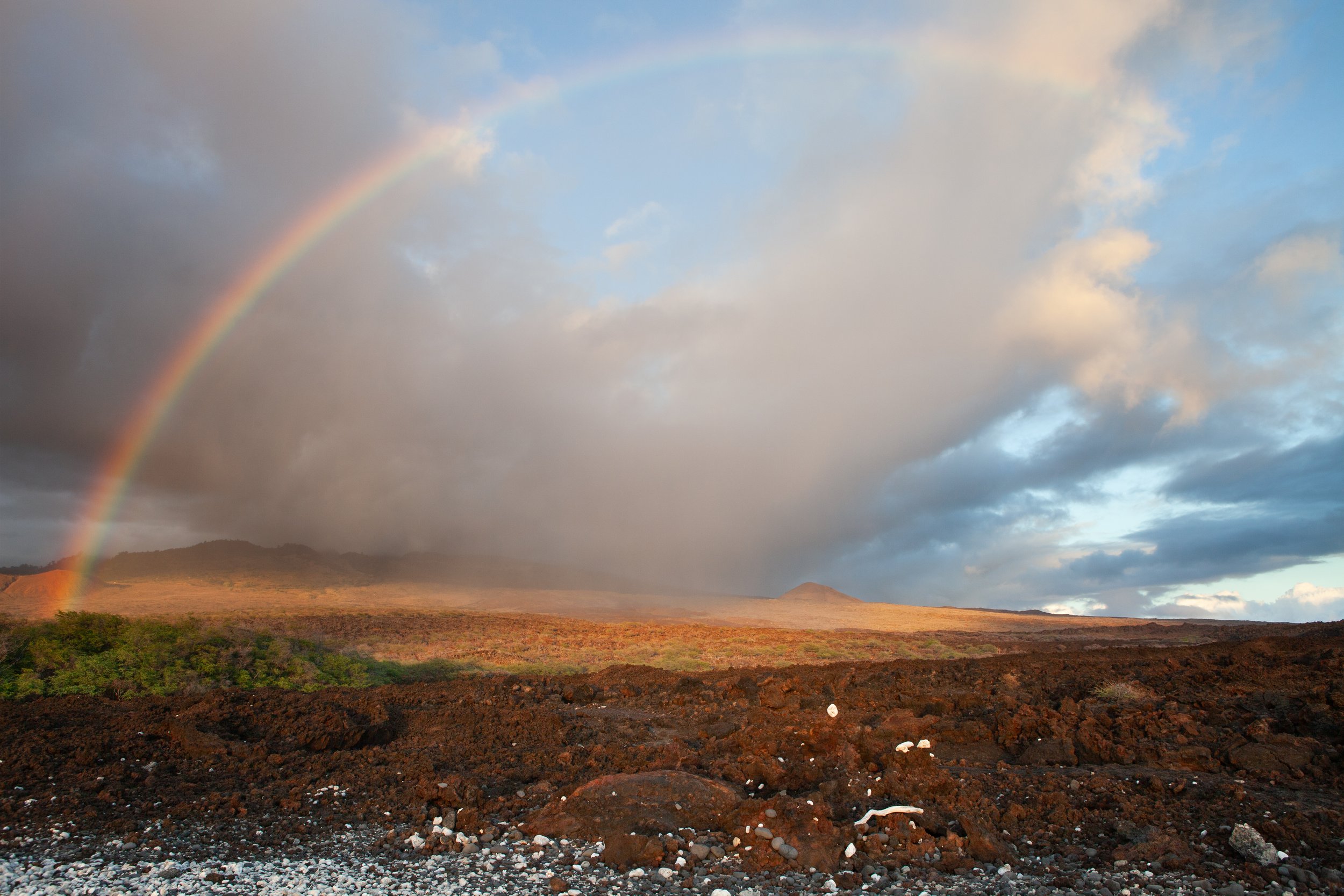 rainbow over a rocky maui landscape