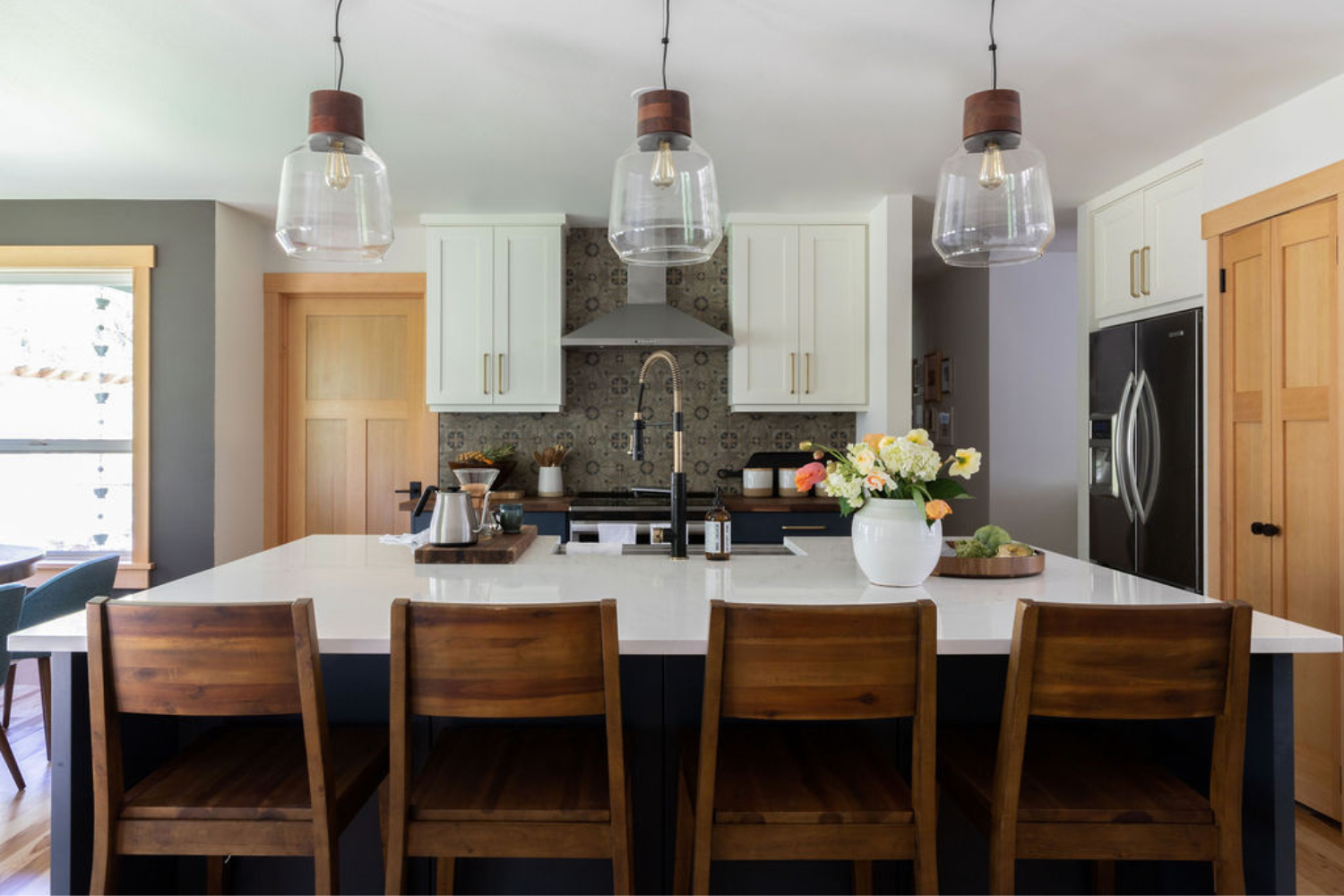 Open concept kitchen remodel with large island, walnut stools, and custom range wall on Vashon Island by Harpole Home