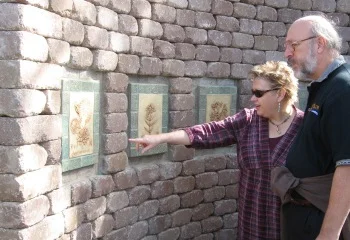 Set into the wall behind the statue are ten ceramic tiles by Tulsa artist Cynthia Harris. Each etching depicts a different flower in the style of Linnaeus.
