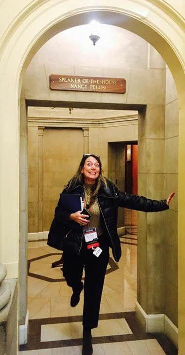 Executive Director Julie Baker strikes a pose in front of Speaker Pelosi's office.