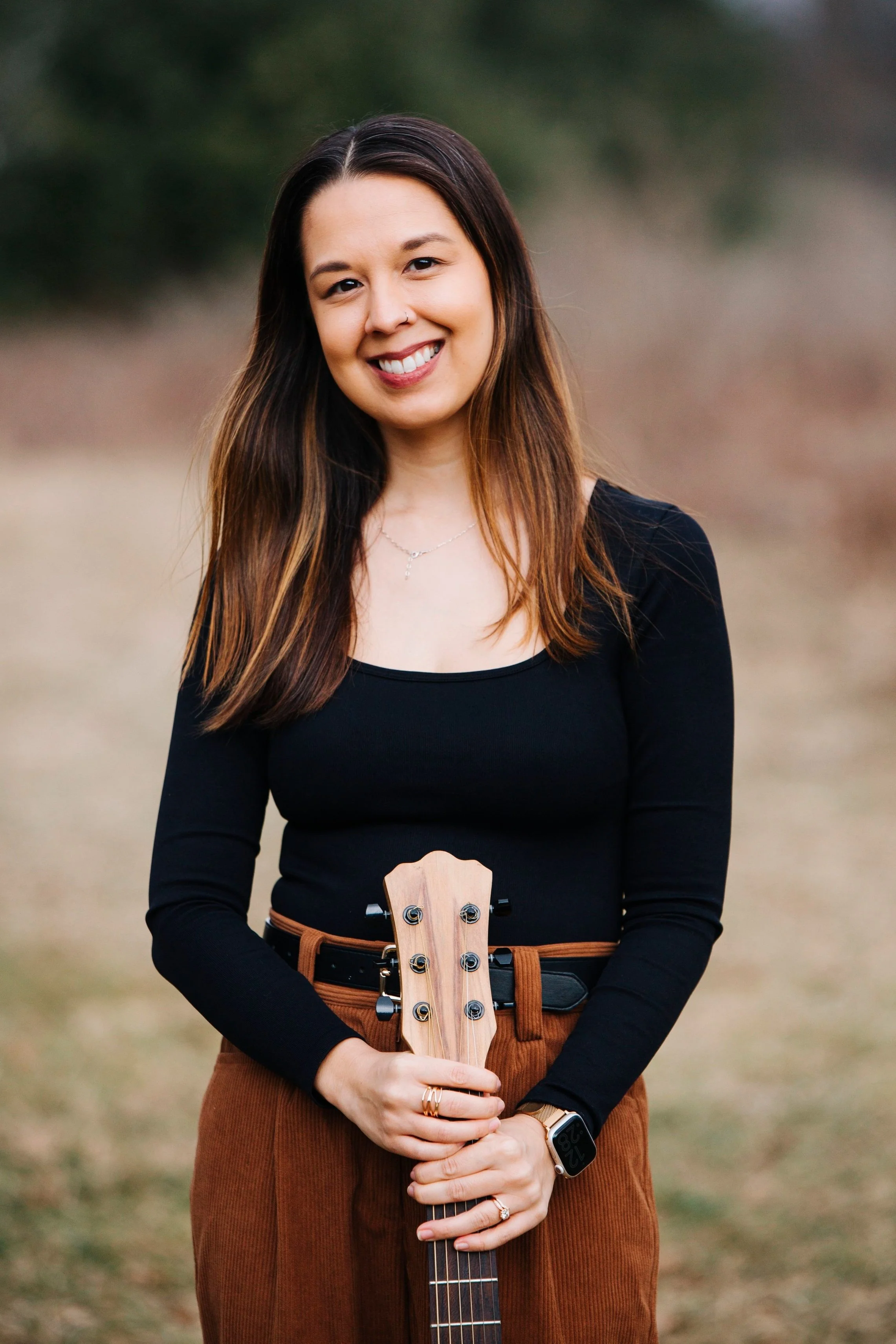 Amanda Maestro-Scherer, board certified music therapist, stands holding a guitar