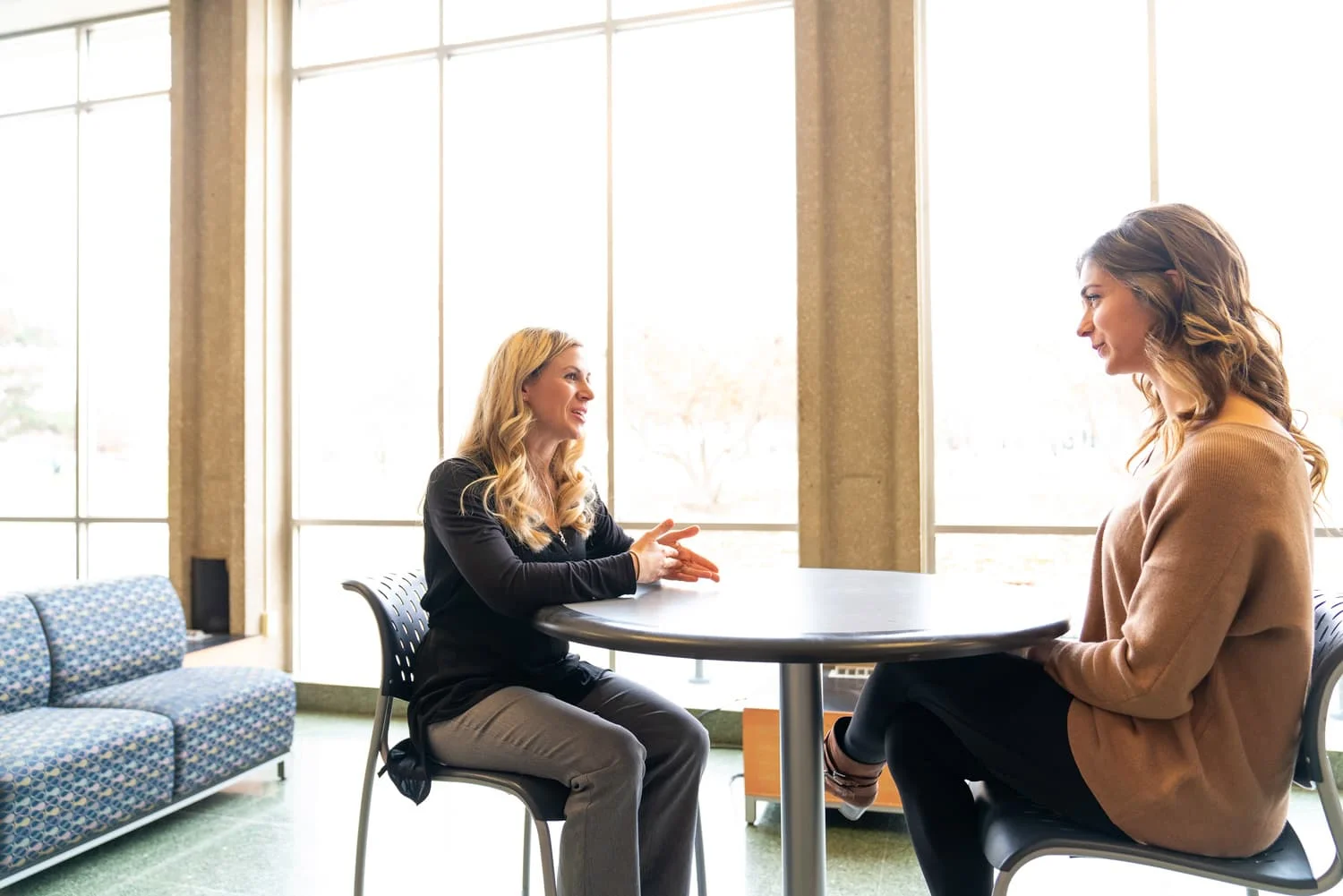 student and advisor talking near windows