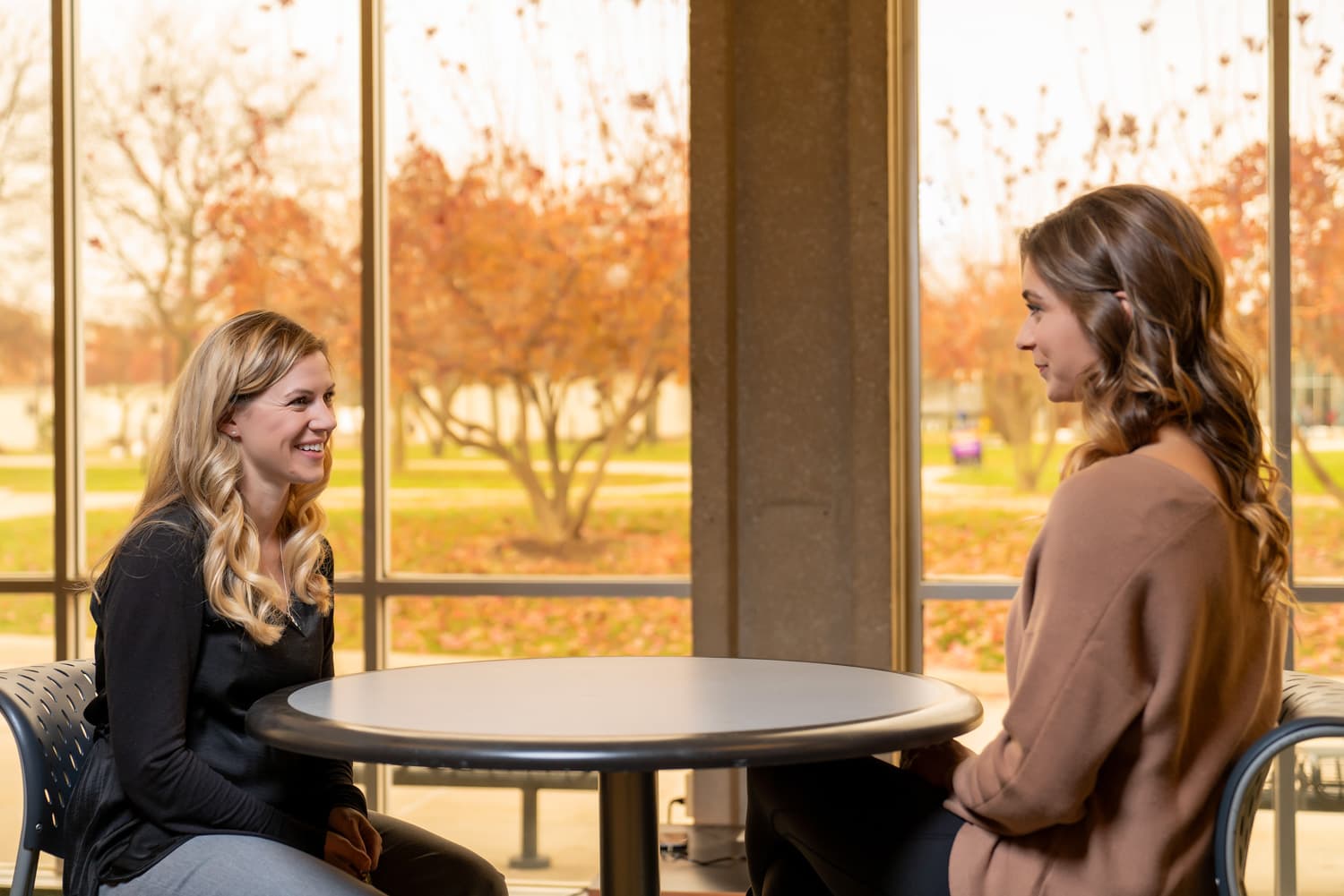  student and advisor talking at a table 