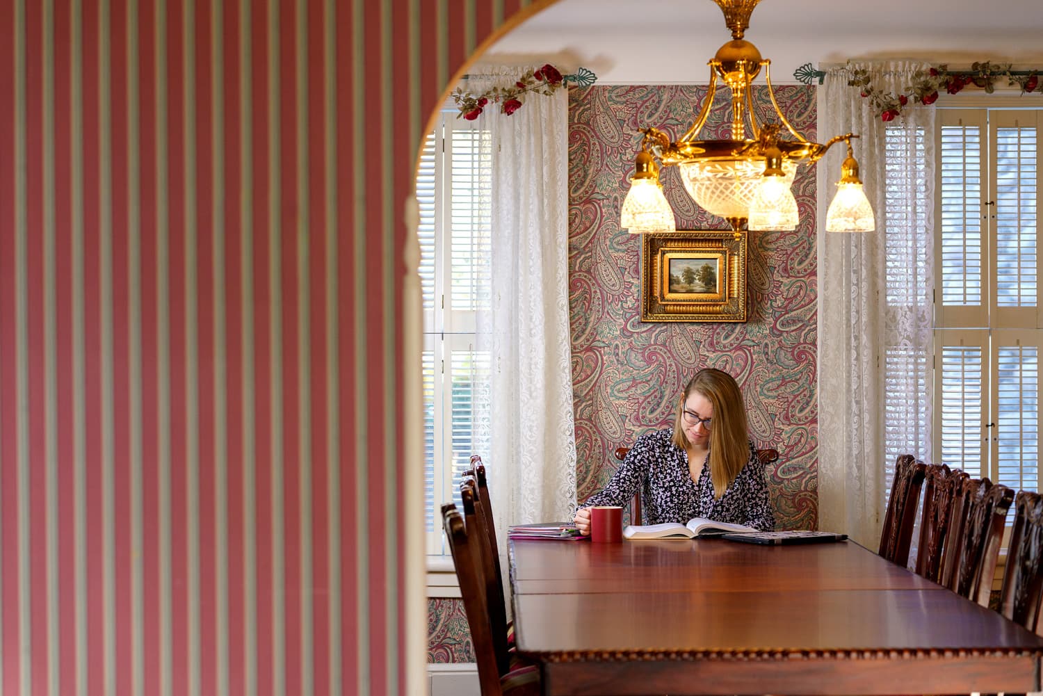  student with coffee at dining room table 