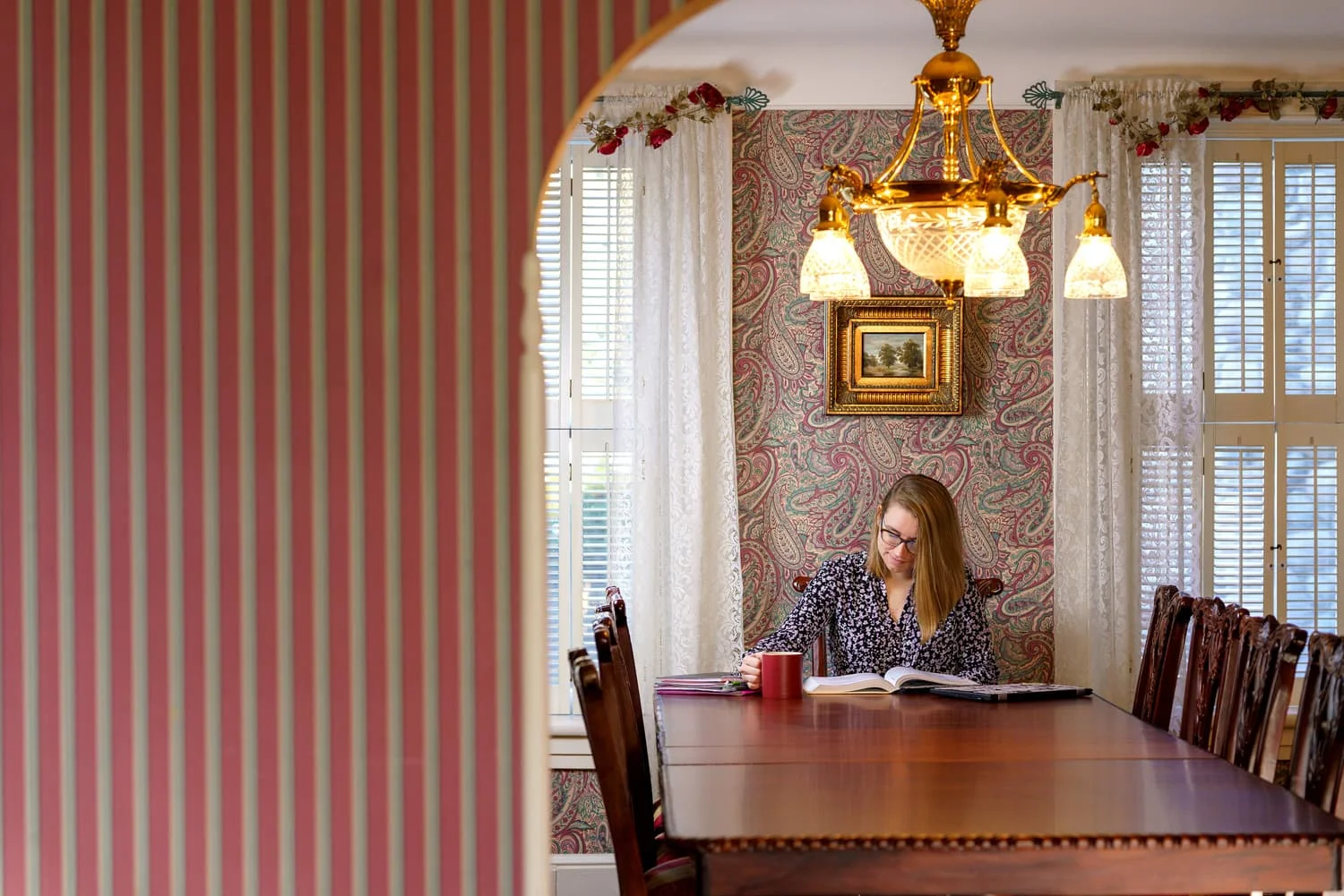 student with coffee at dining room table