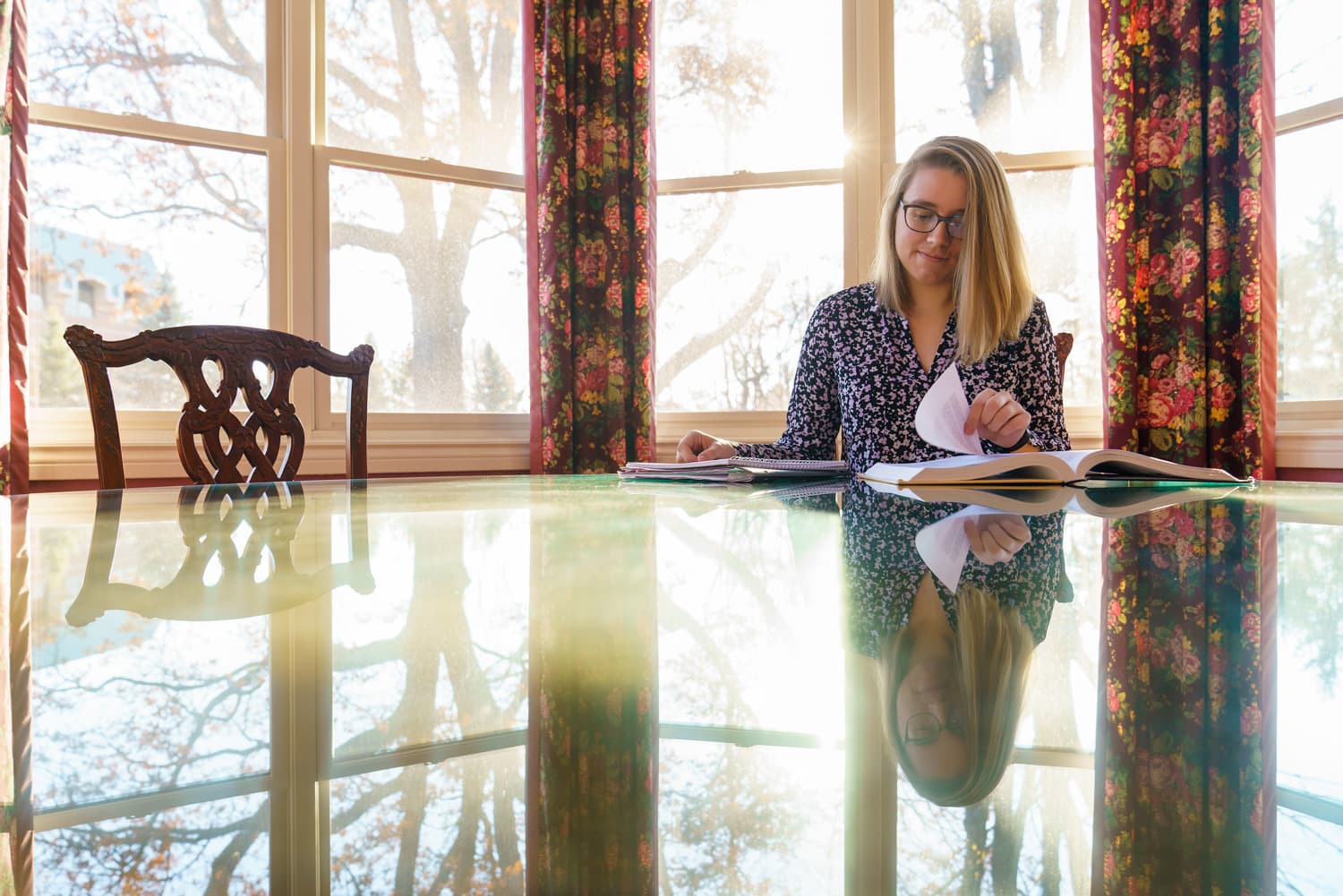  student flipping pages of book at table 