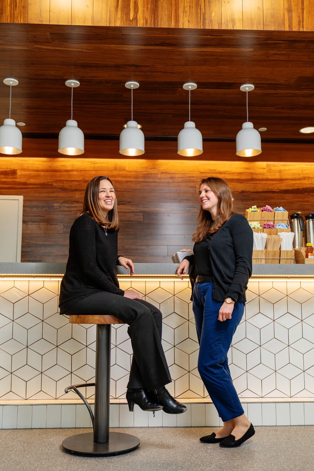  two people smiling at cafe counter 