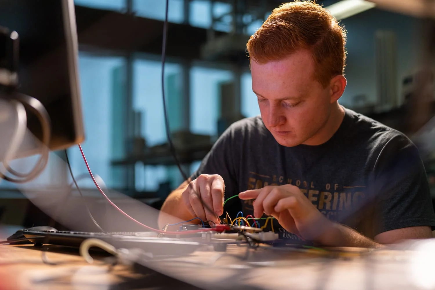 Engineering student tinkering with circuit board