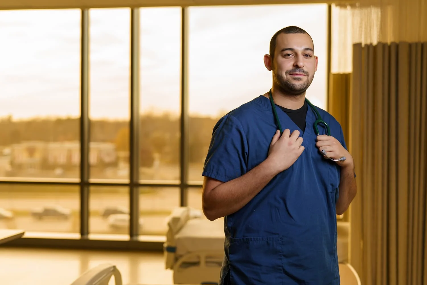 Nurse in blue scrubs holding a stethoscope