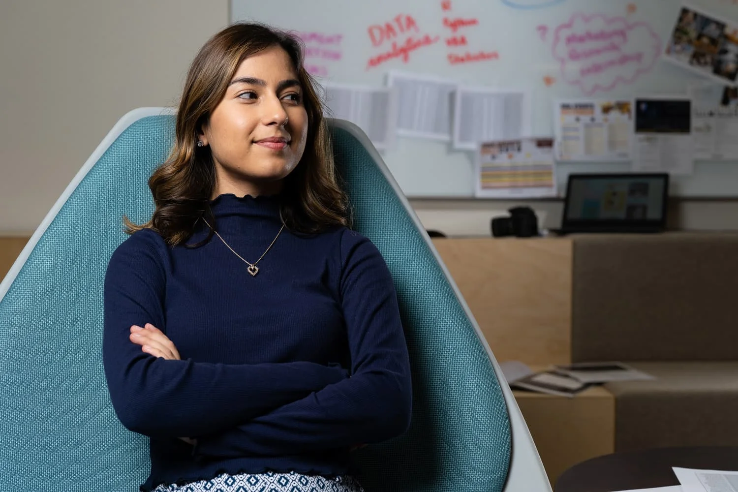 student sitting in chair with arms crossed.