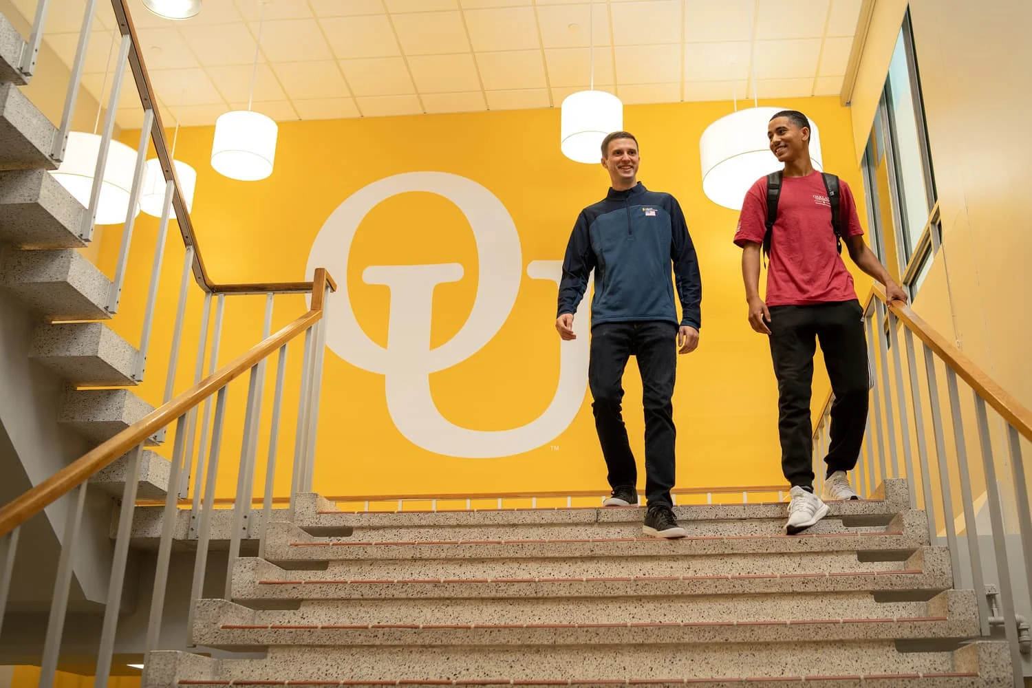 2 students walking down stairs