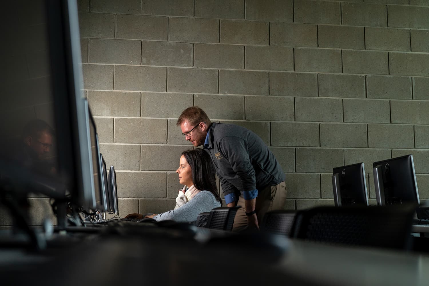  Two colleagues looking at computer monitor 